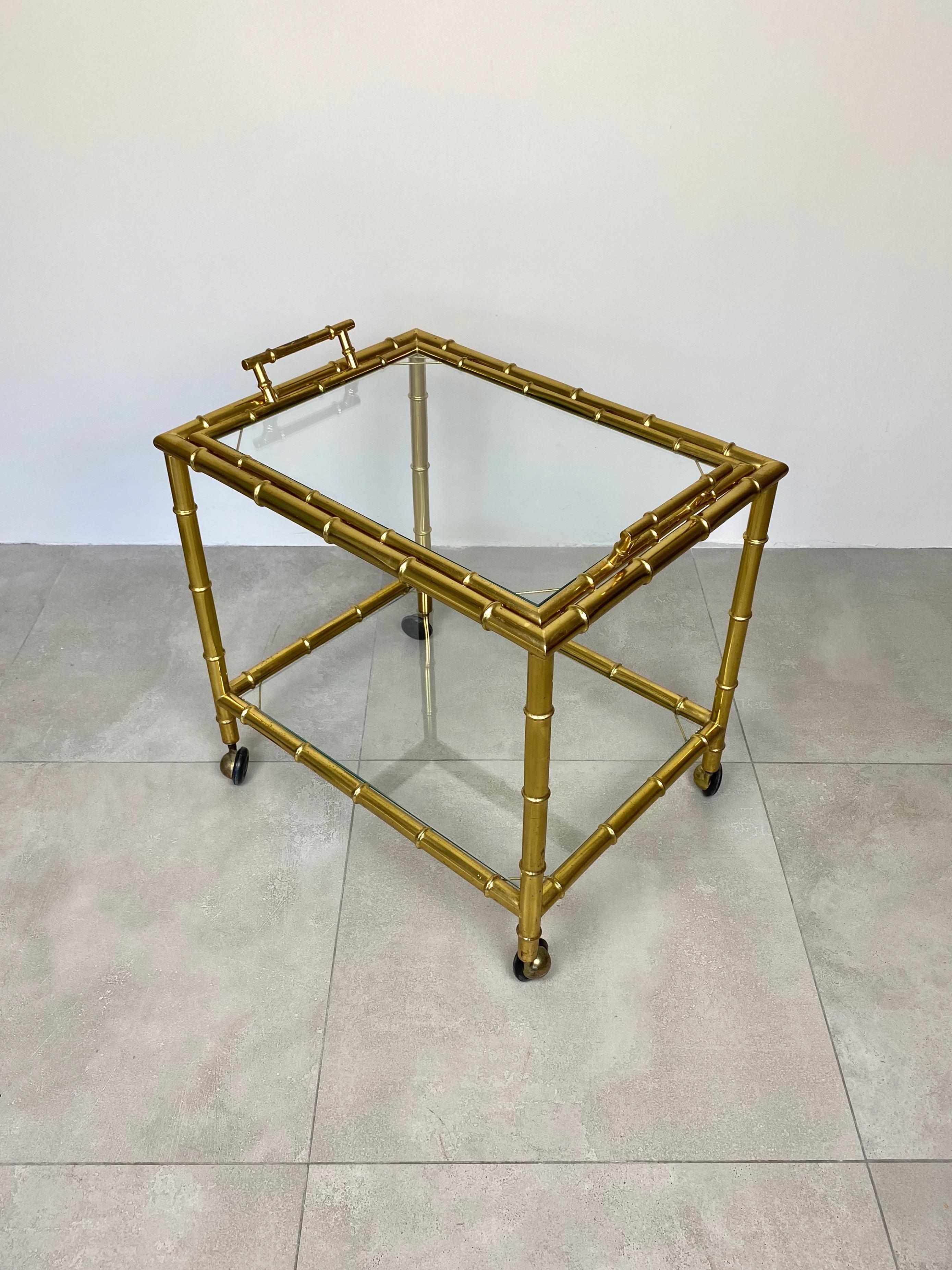 Serving bar cart in a brass structure with bamboo effect and glass shelves, the upper one removable and usable as a separate tray. Made in Italy, circa 1960s.