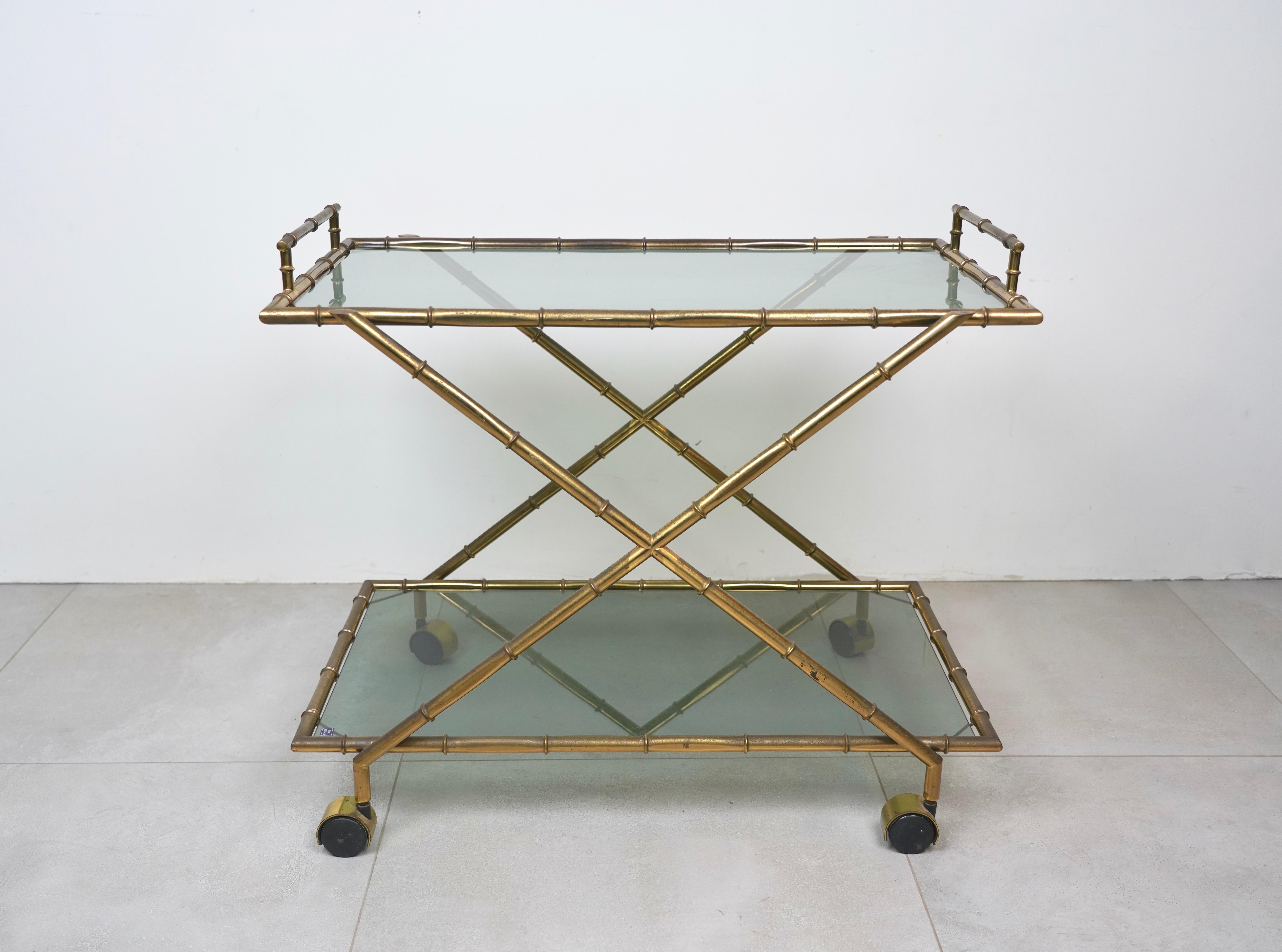 Elegant French bar trolley with solid faux bamboo brass frame and two smoked glass shelves. Marked 