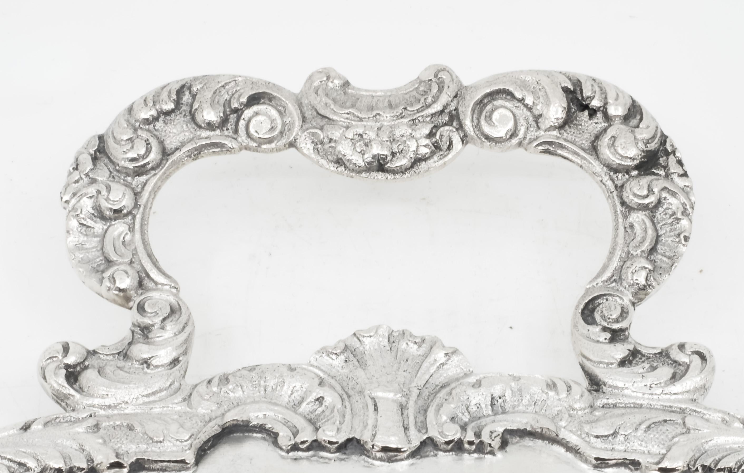 German late 19th-early 20th century oval shaped silver 800 serving tray with scroll handles.
The stepped surface is worked in a border decorated with foliage scrolls and shell motifs. Both handles feature C-shaped scrolls
The piece is hallmarked