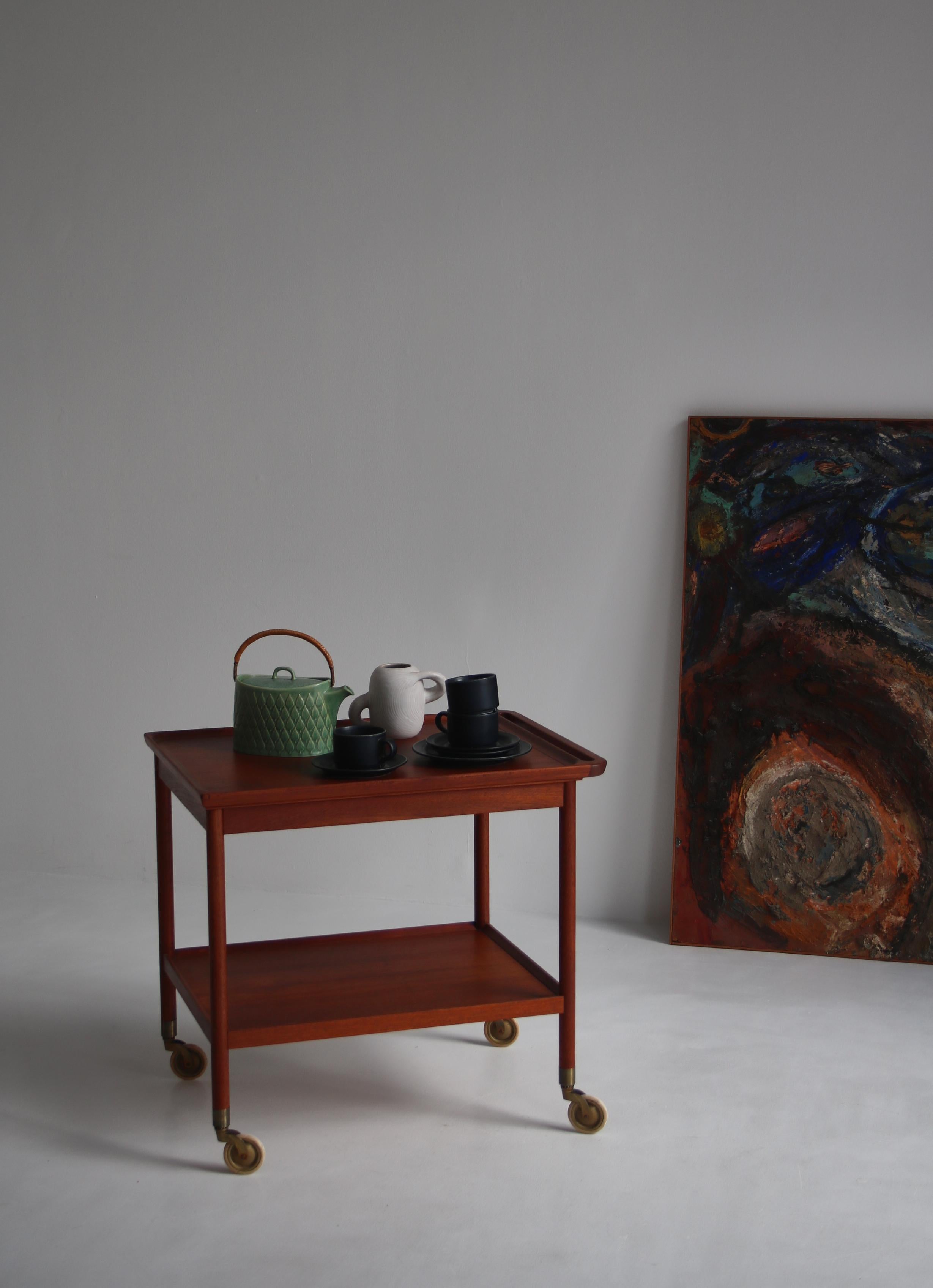 Danish master cabinetmaker Ludvig Pontoppidan designed and executed this wonderful teakwood and brass serving trolley in the 1960s. Clean minimal lines with a subtle handle on one end which adds organic depth and character. The brass casters give an