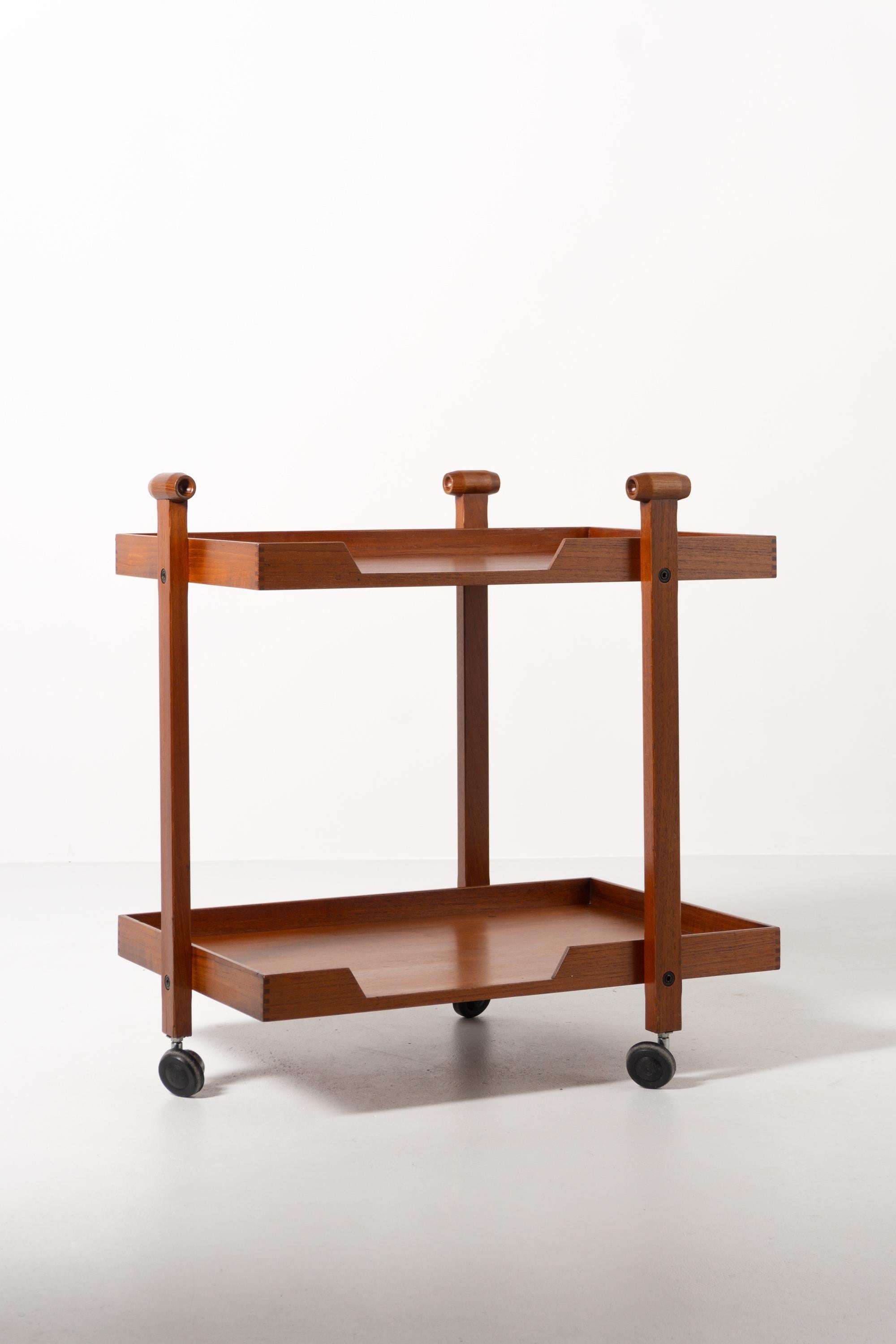 This elegant serving cart (model CR20) made of solid teak as well as plywood impresses with its simplicity. The two tableau level is flanked by three struts placed on casters. Designed by Franco Albini in 1958, who for a short time also worked in