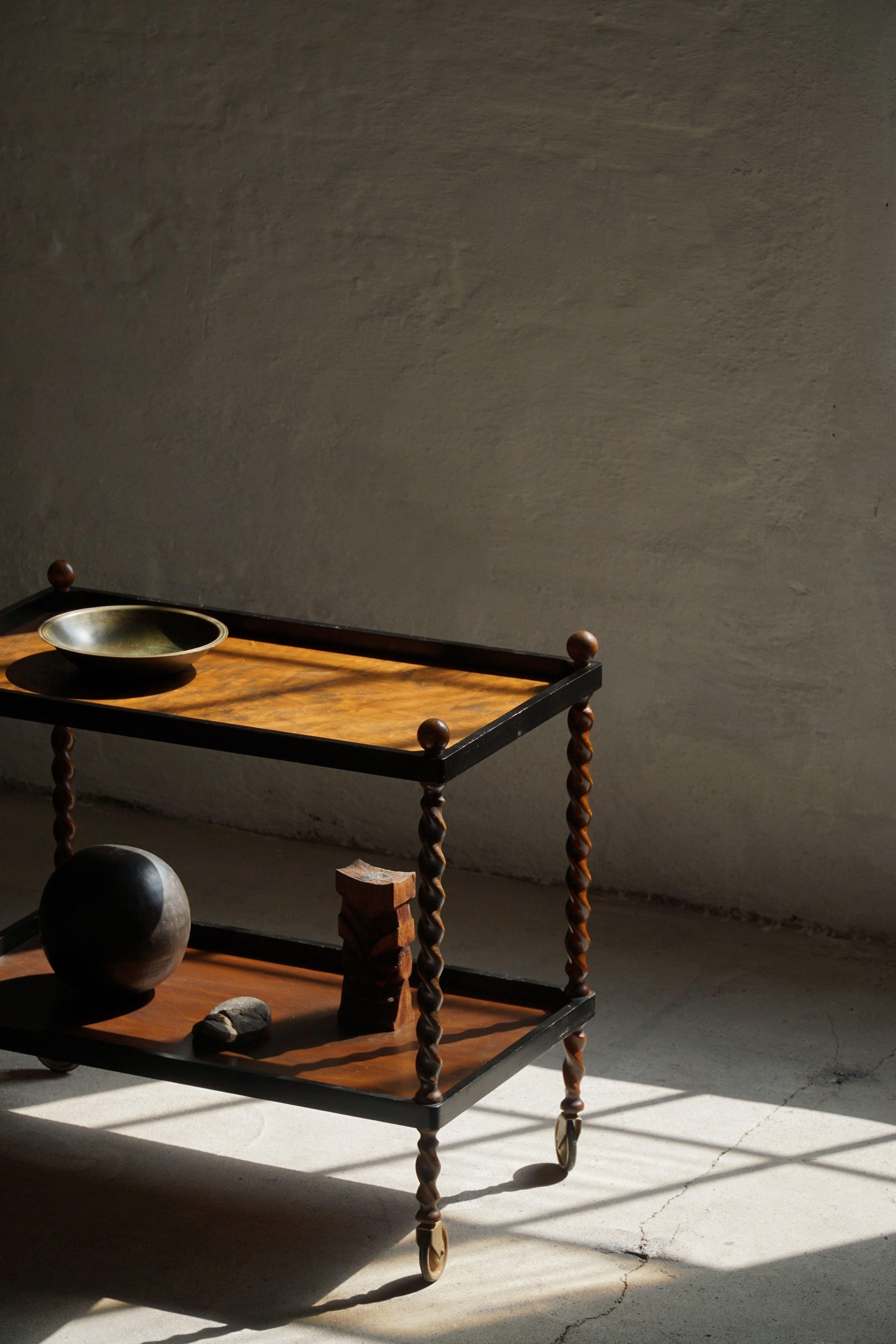 This stunning serving table in oak with twisted legs is a beautiful example of early 20th-century Danish craftsmanship. Made of birch, it features two trays that rest atop gracefully twisted legs, adding sculptural elegance to its functional design.