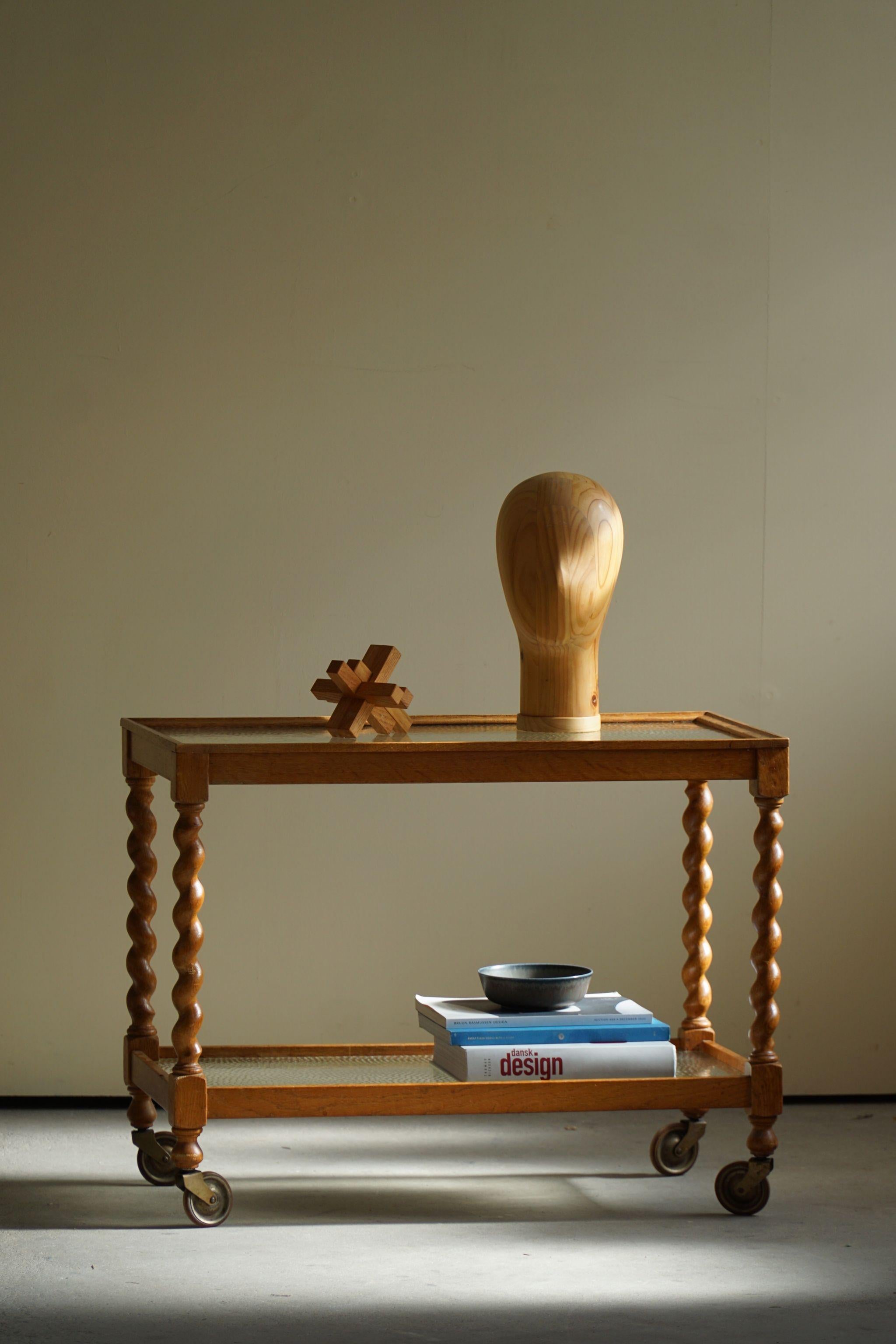 Dieser wunderschöne Serviertisch aus Eiche mit gedrehten Beinen ist ein schönes Beispiel für die dänische Handwerkskunst des frühen 20. Jahrhunderts. Er ist fachmännisch aus hochwertigem Eichenholz gefertigt und besticht durch sein elegantes und