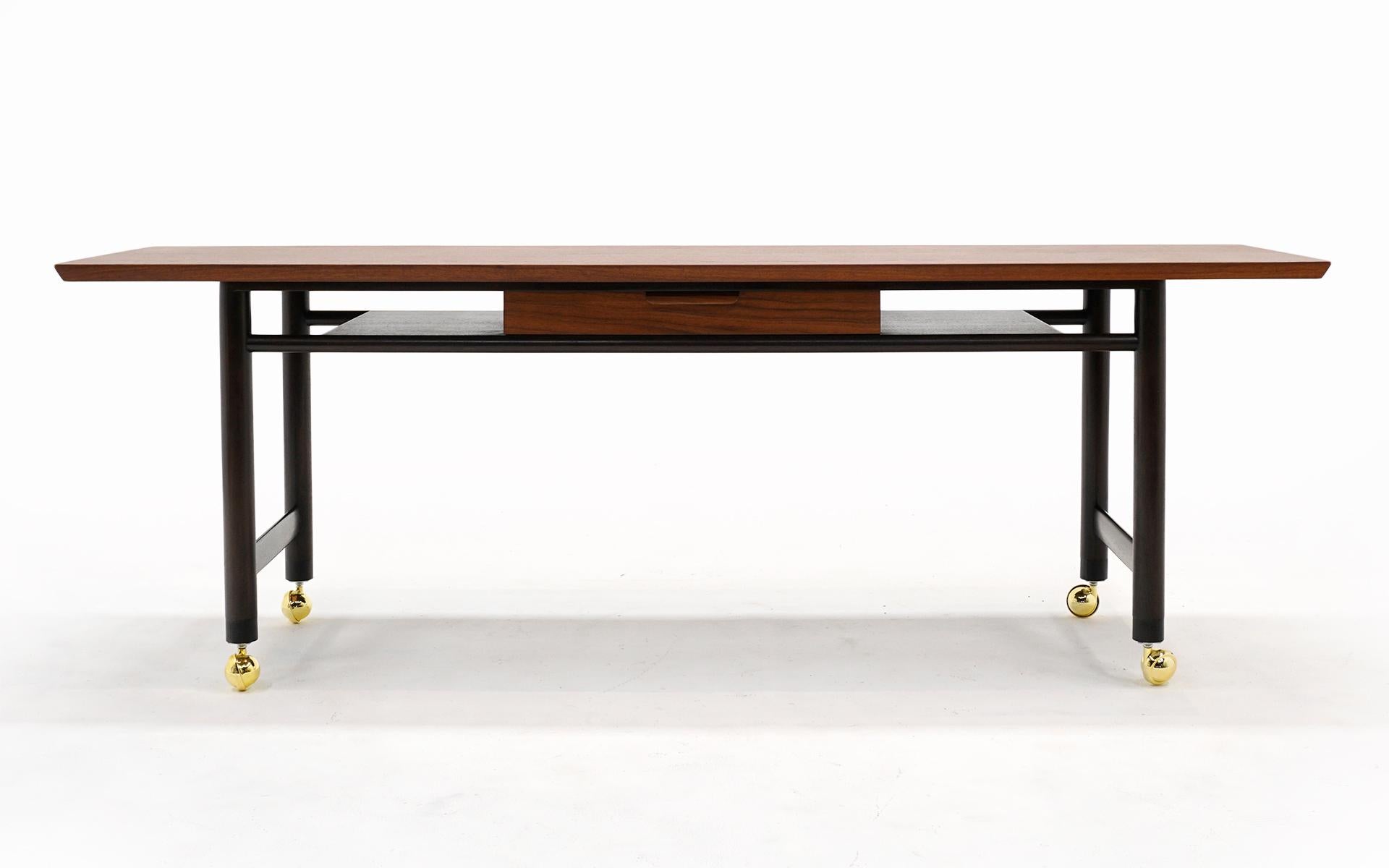 Rare table de service / console avec tiroir conçue par Edward Wormley pour Dunbar, années 1950. Dessus en noyer très ouvragé, base en acajou foncé et roulettes en laiton. Nous l'avons acquis auprès du propriétaire d'origine. Rénové par des experts.