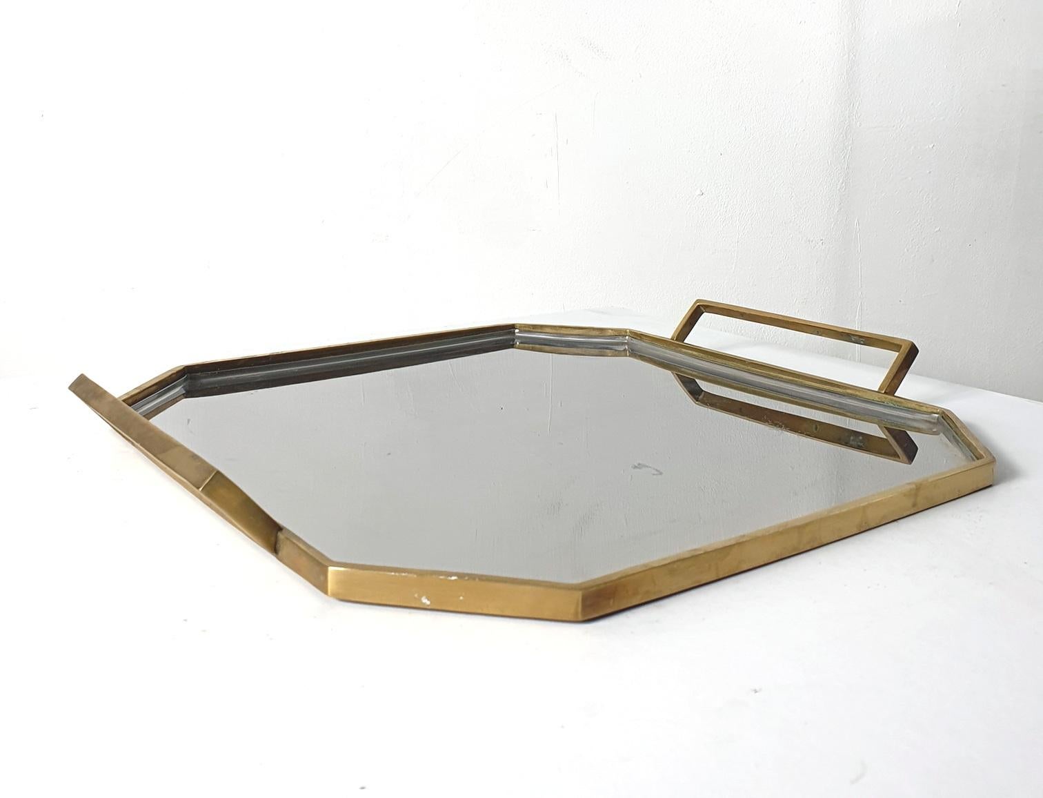 Glam octactonal tray in inox and brass with handles. It is very solid and well made in the execution and carries some weight. Perfect for serving your cocktails and snacks on. In very good condition.