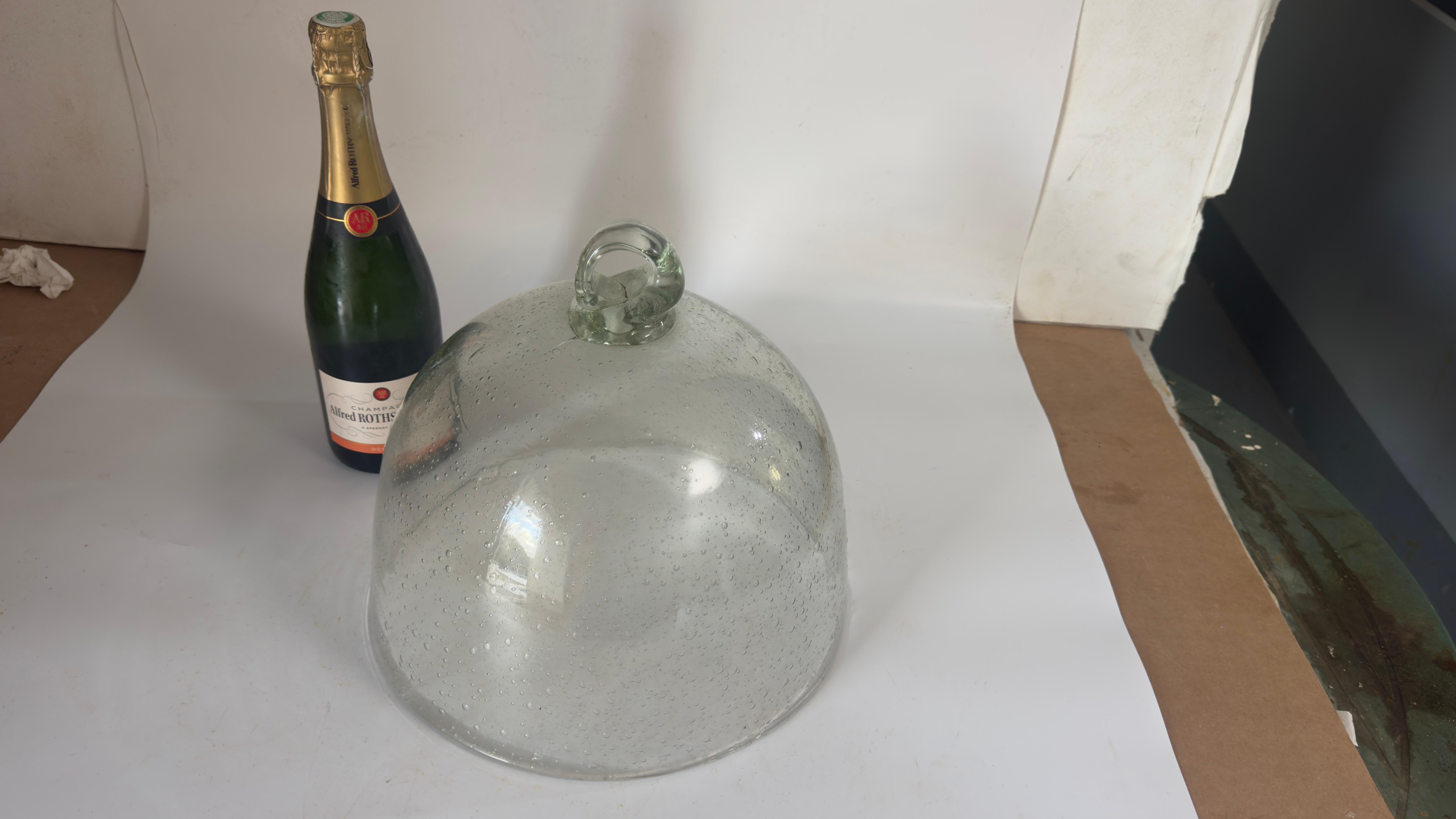 Esta exquisita campana de cristal, fabricada por la renombrada cristalería Biot del sureste de Francia, es una mezcla perfecta de arte y funcionalidad. Conocidas en todo el mundo por su excepcional artesanía, las creaciones de Biot son fácilmente