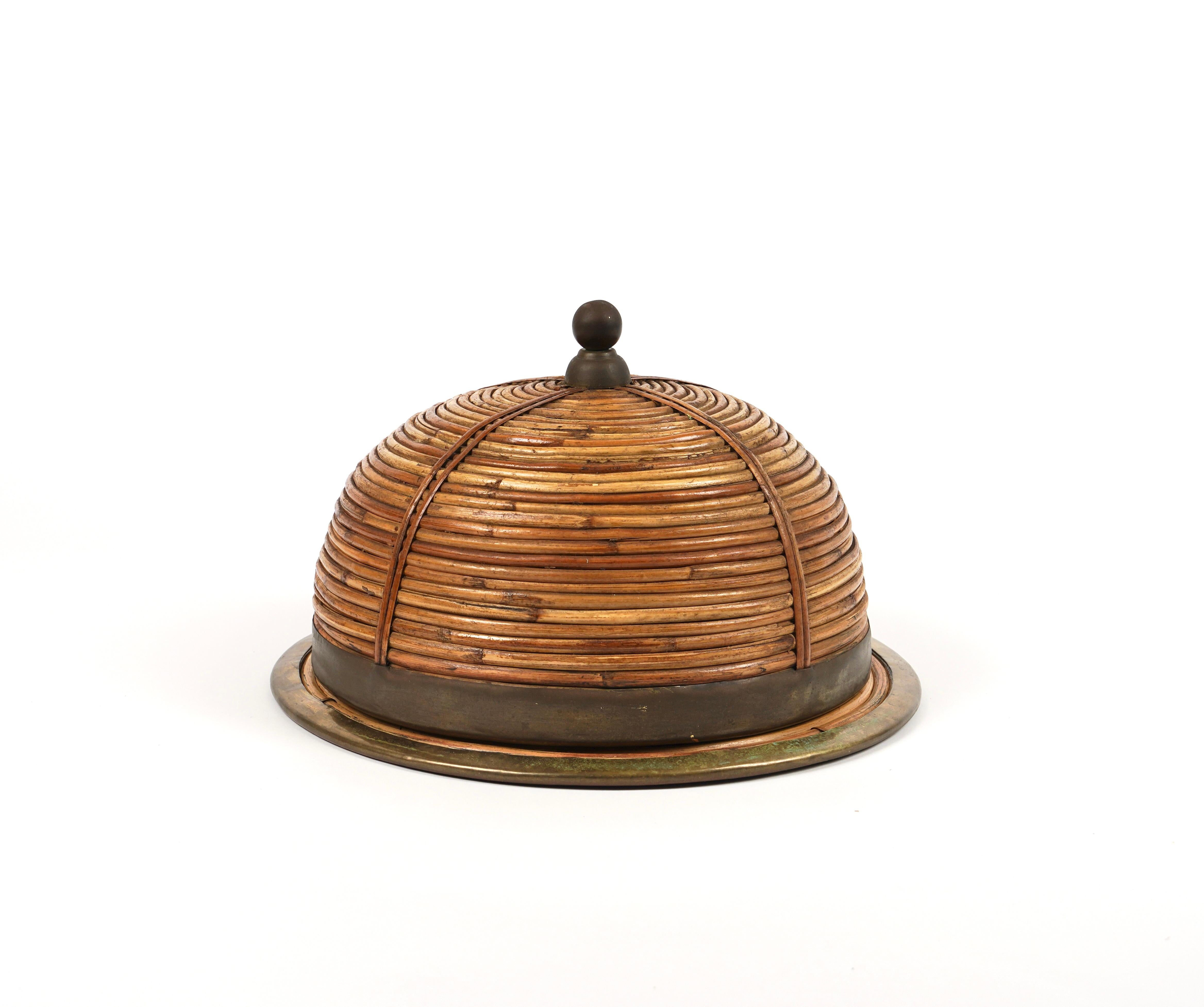 Gorgeous serving tray cloche plate in rattan and bamboo with brass details probably by the Italian Gabriella Crespi.

Made of rattan and bamboo, this charming piece is in the typical style where the organic beauty of the woven materials is