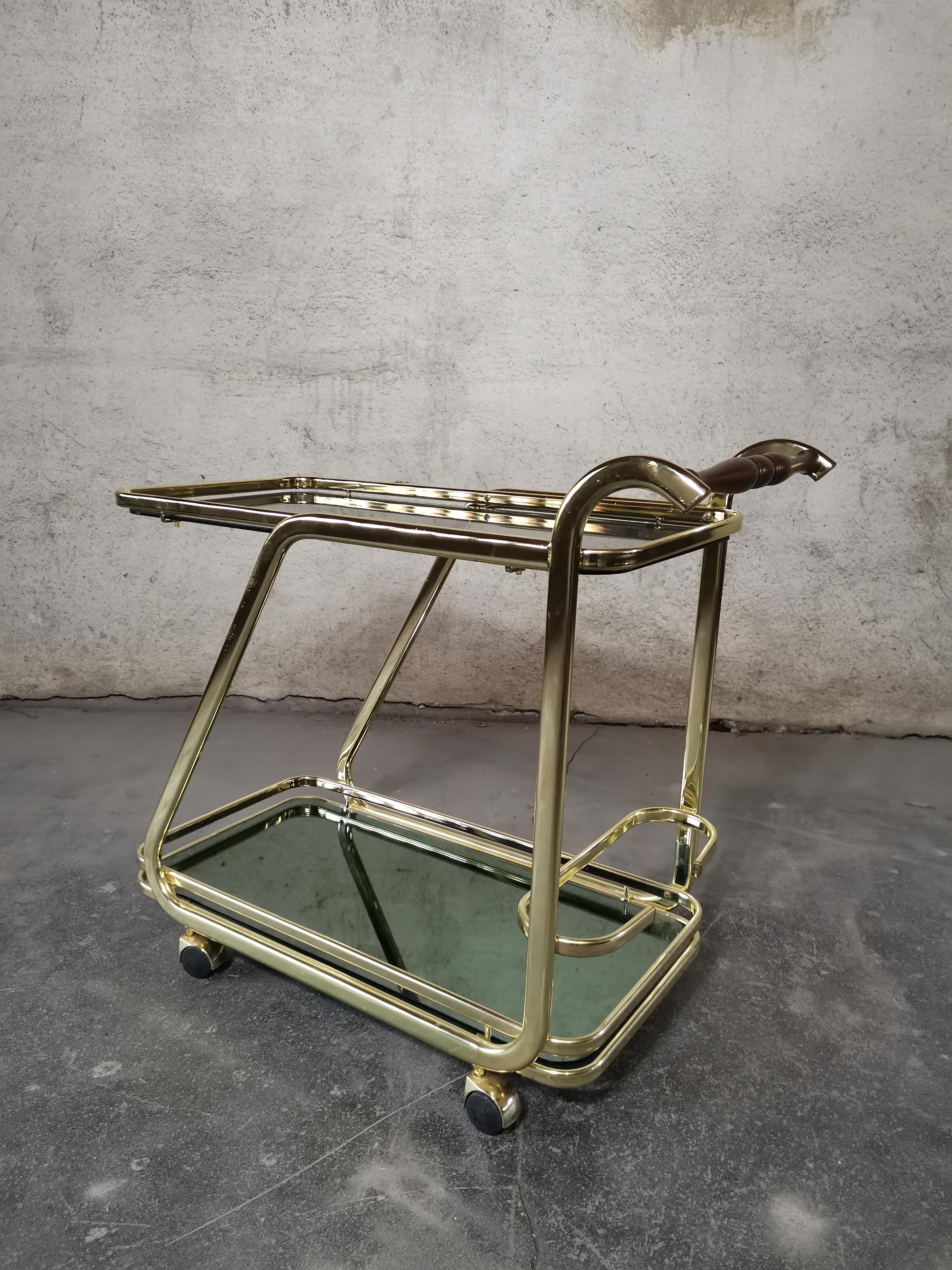 Servierwagen 1970er Jahre

Trolley mit Rauchglas/Holzgriff/Vergoldung/schöner Patina.

Gefertigt von italienischem Design und auch Hersteller (detailliert).

Die obere Fläche ist 64,50 cm hoch, die untere 12,50 cm. Der Griff hat eine Höhe von 83 cm.
