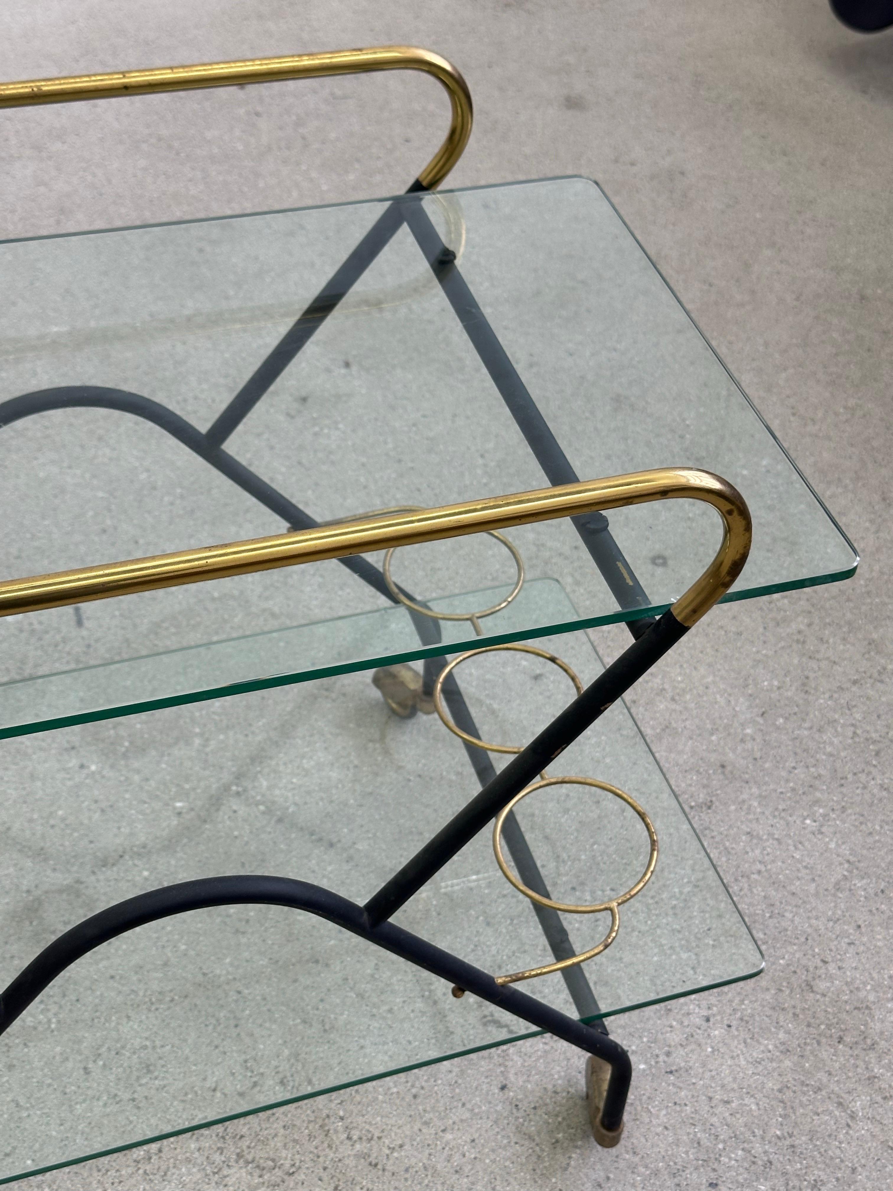 Chariot italien des années 1950. (Table de service) (bar) Cette pièce très élégante est composée de deux plateaux en verre et d'une structure en métal, or et noir. Les roulettes fonctionnent très bien, elles sont très chics. On retrouve des détails