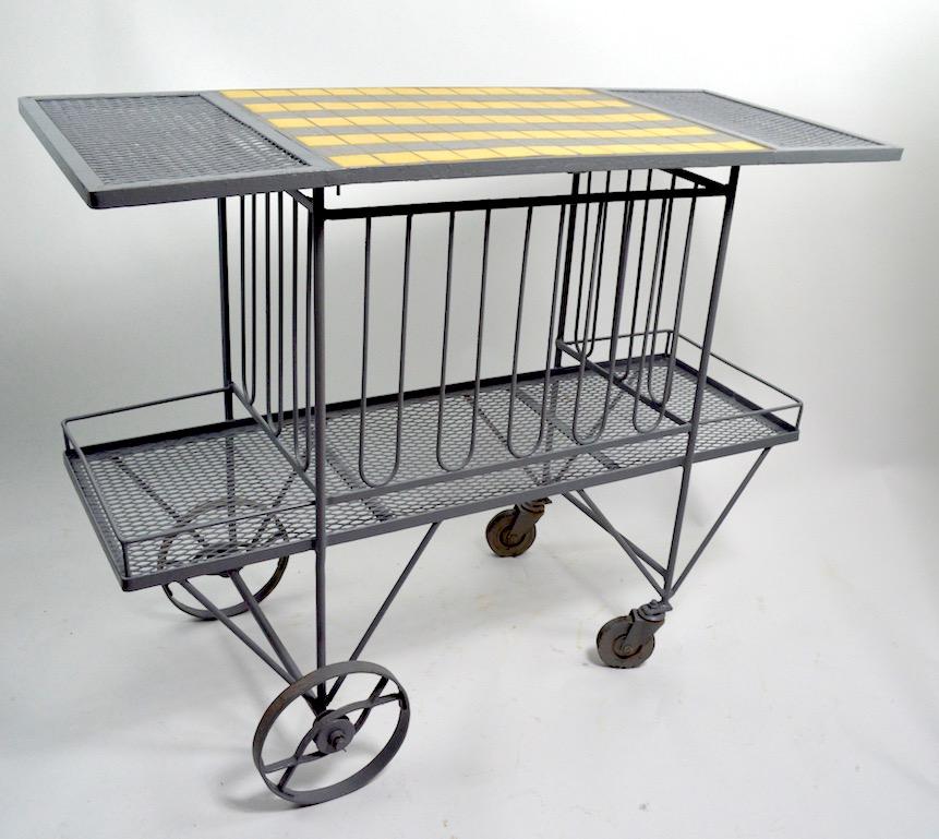 Interesting serving trolley designed for Salterini by Tempestini. The cart has two tiers, the top having a tile surface, for preparing drinks and snacks. Cart suitable for indoor and outdoor use. Currently in later grey paint finish, cart shows