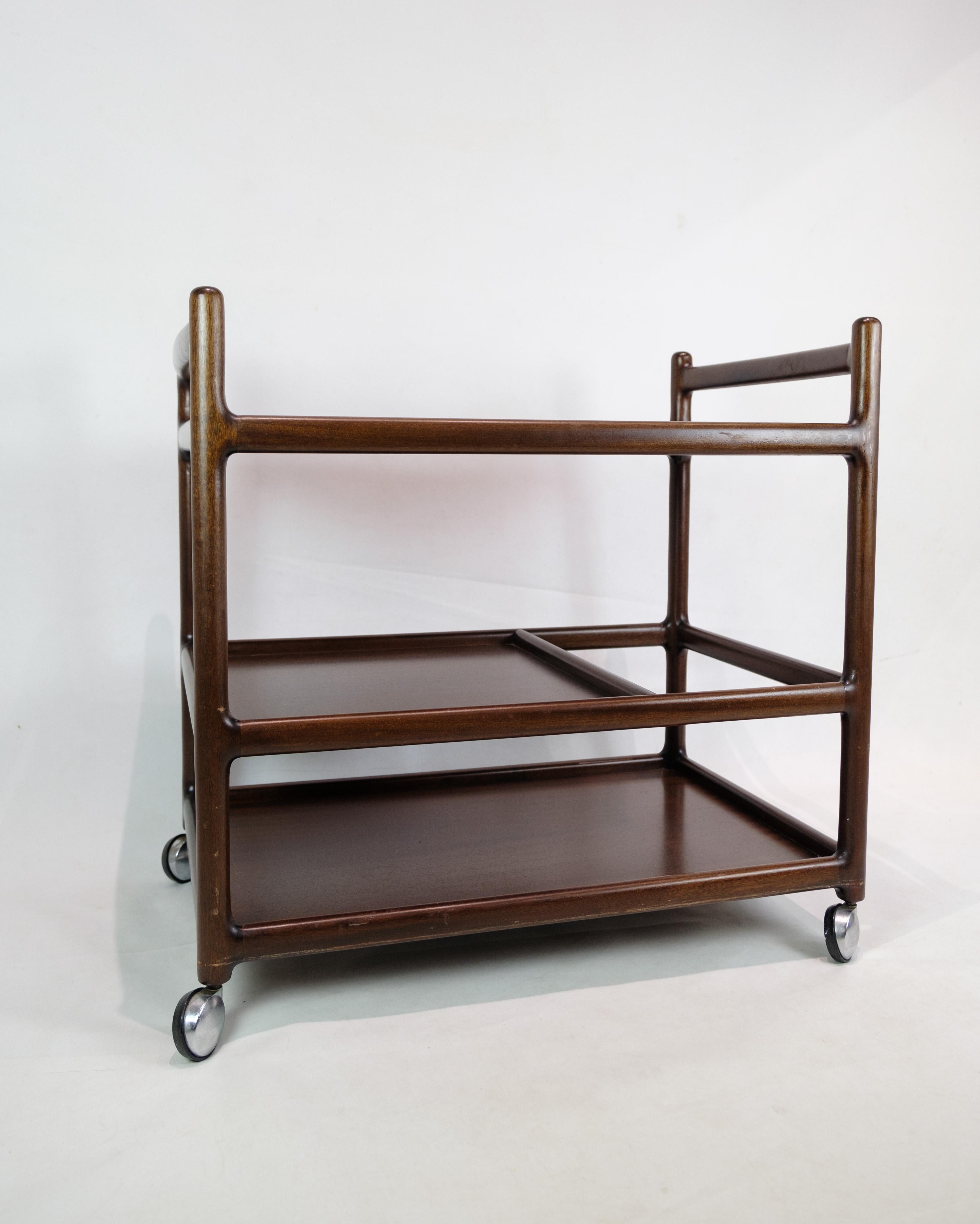 This serving trolley is an enchanting example of Johannes Andersen's design aesthetics from the 1960s and was produced by Silkeborg Møbelfabrik. Made of mahogany wood, the carriage exudes a warm and welcoming atmosphere, typical of this era of