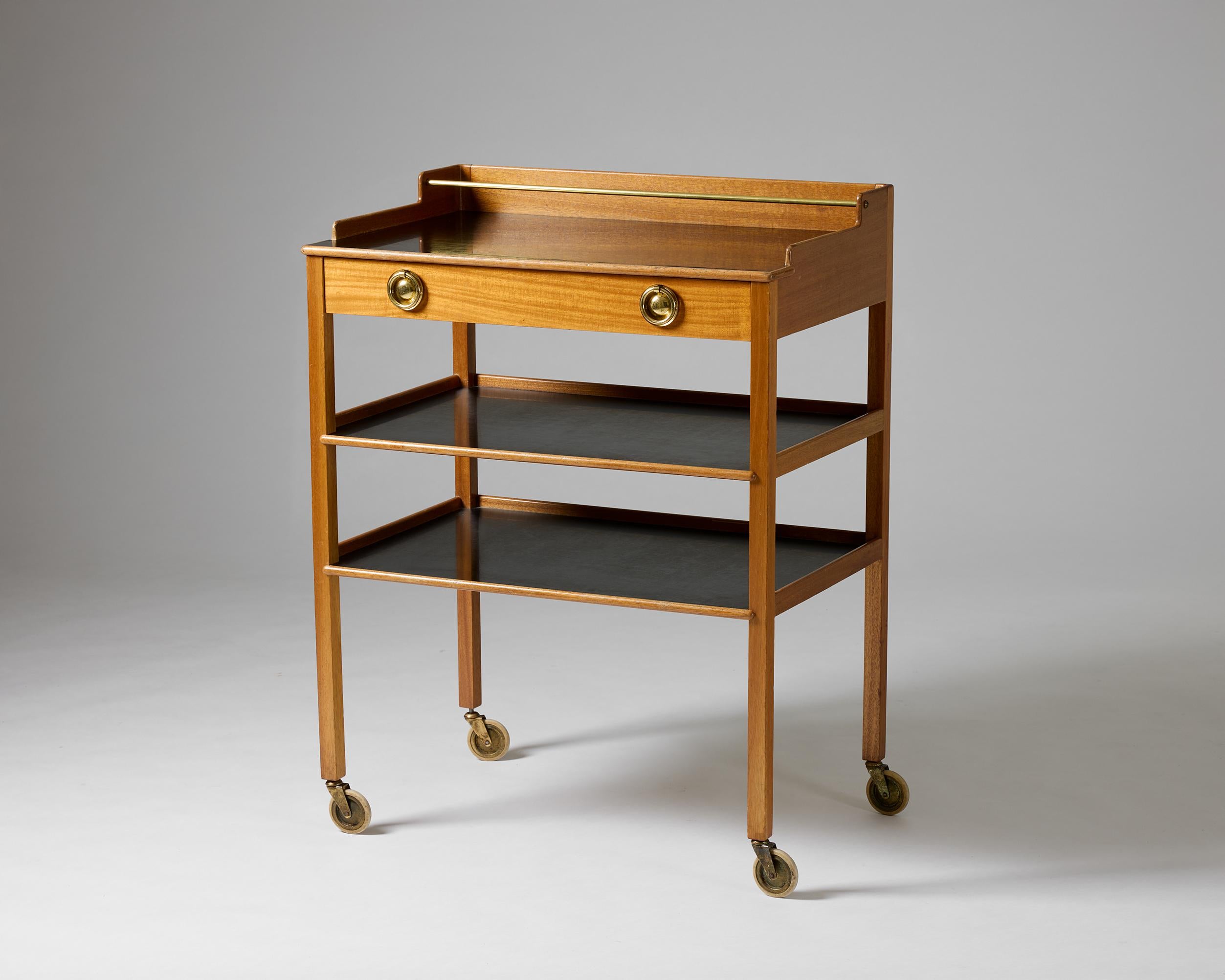 Serving trolley model 2777 designed by Josef Frank for Svenskt Tenn, Sweden, 1950s.

Mahogany with a black arborite top. Brass handles. 

H: 105 cm / 41 3/8