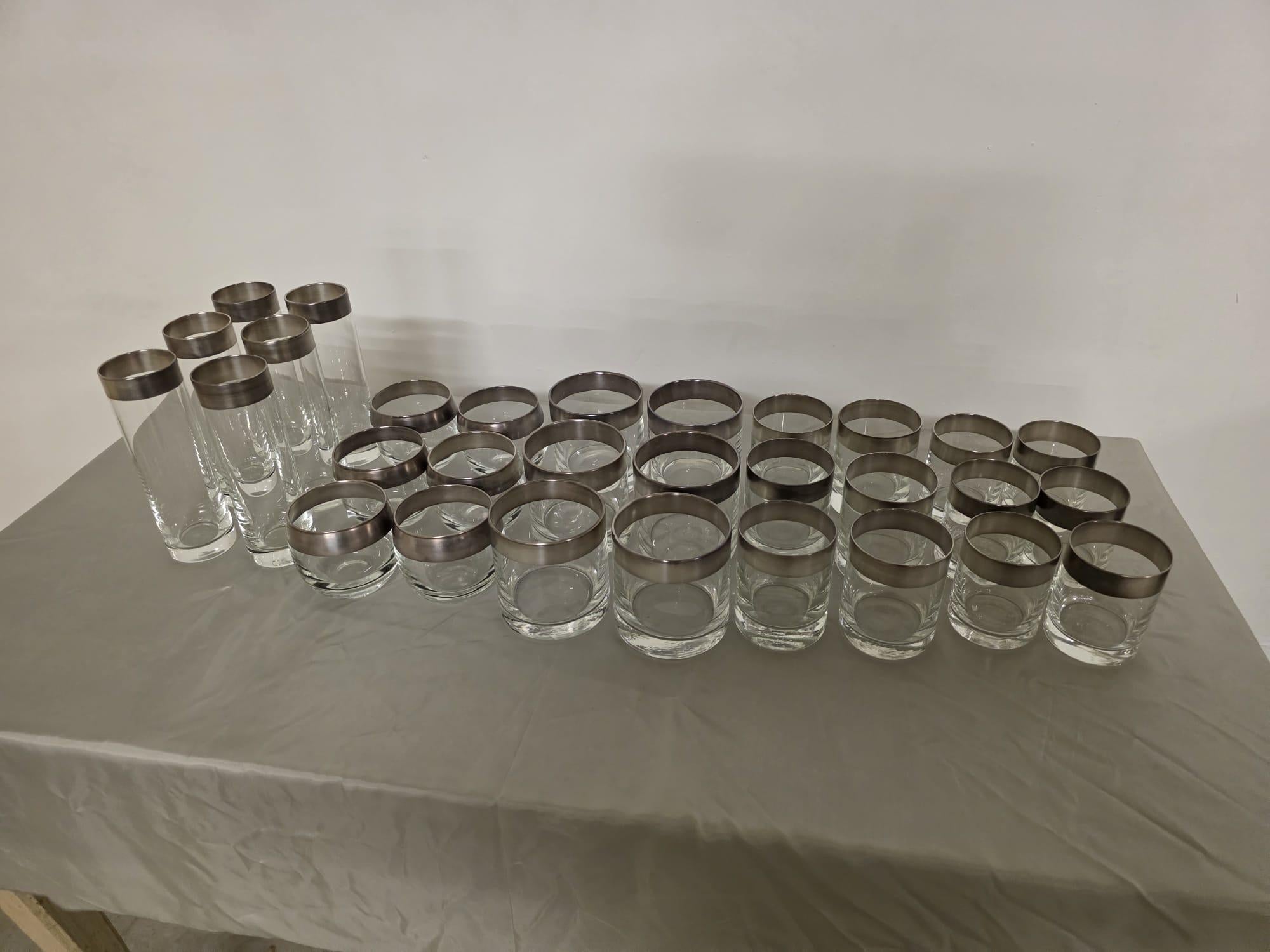 1960s glass service by Thorpe inc.

Service de table raffiné en verre soufflé caractérisé par une large bande sur le bord supérieur en argent sterling.

Produit par la société américaine Dorothy Thorpe, Inc.

L'entreprise a été fondée par la
