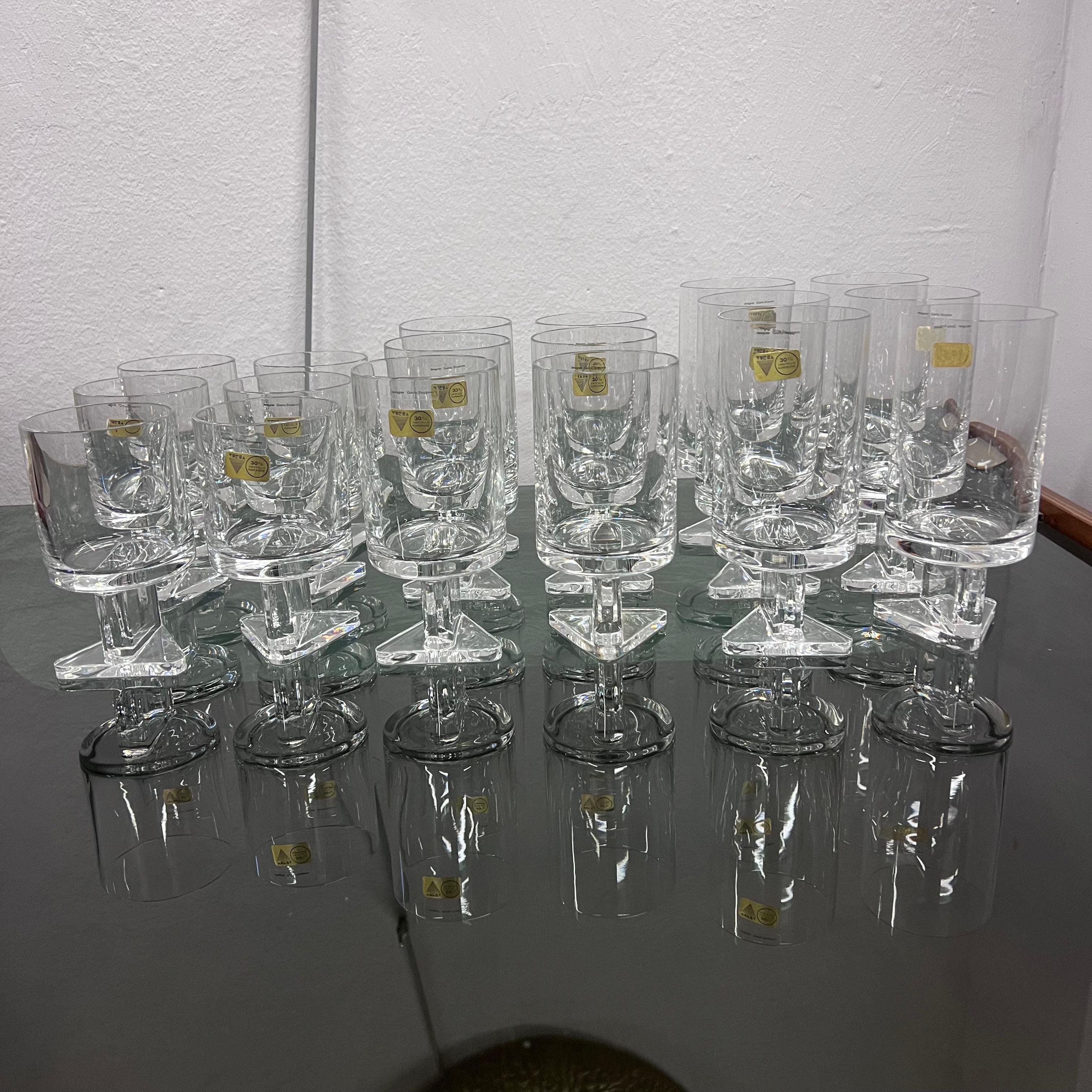 Original six-person glass service divided into: 6 water glasses, 6 white wine glasses, 6 red wine glasses, total of 18 pieces.
Designed by Giotto Stoppino, in an original form that harkens back to the Space Age period, they have a triangular base