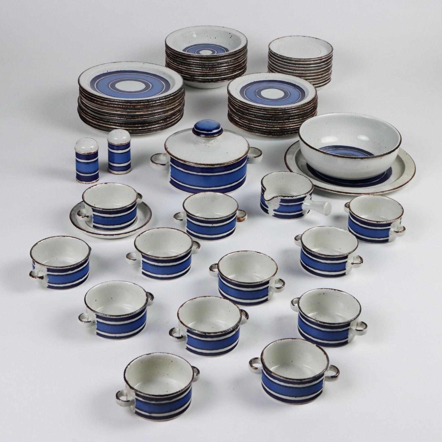 Geschirr aus weiß glasierter Keramik und in Blautönen. Das Set besteht aus 12 Suppentellern, 12 flachen Tellern, 12 Obsttellern, 12 Suppentassen mit Untertasse, 1 Schüssel mit Hülsenfrüchten, 1 Salatschüssel, 1 runder Servierteller, 1 Sauciere,