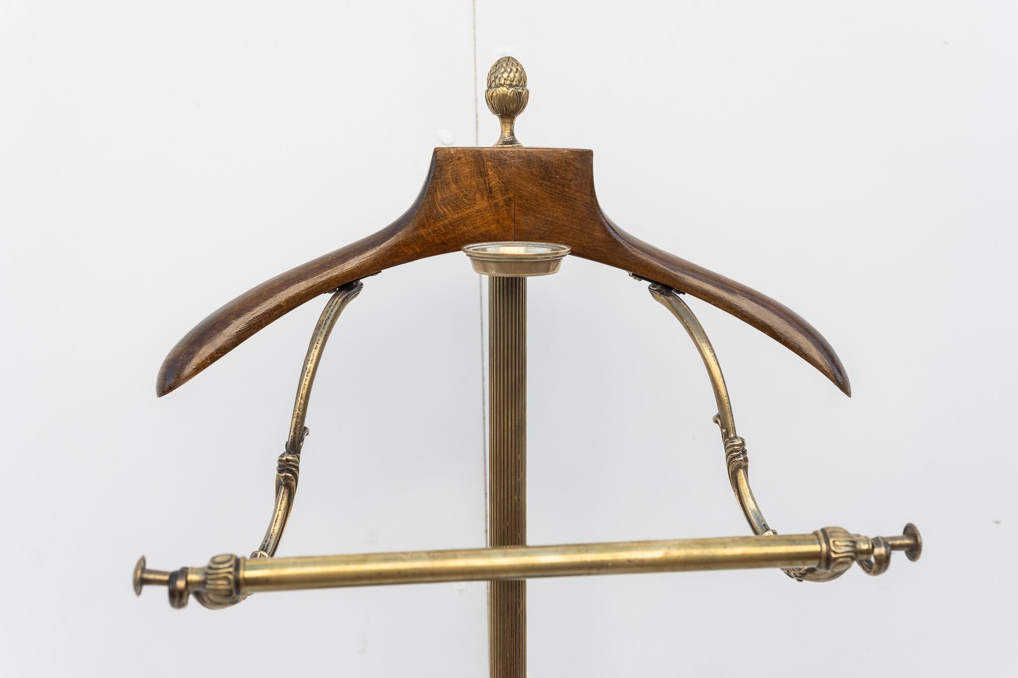 Servomuto in ottone e legno, Anni '40, Made in Italy.
Rarissimo Servomuto in ottone con appendi giacca in legno. La struttura è interamente in ottone e termina alla base con un piano in legno rivestito in velluto. La parte perimetrale della base è