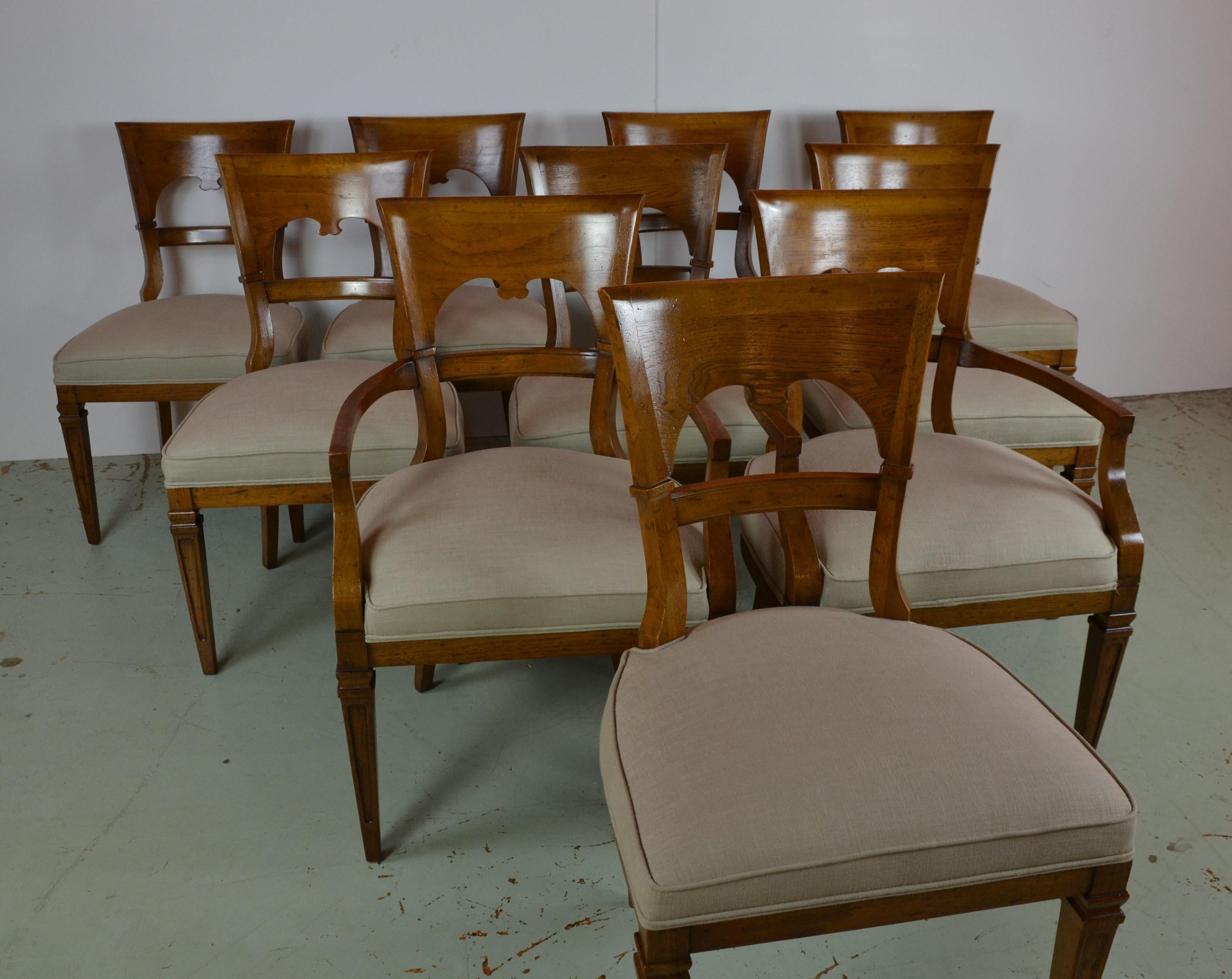 An unusual set of 10 dining chairs in pecan-wood. Having a transitional style of Formal to Country. Quality made chairs. Newly upholstered in a neutral linen.