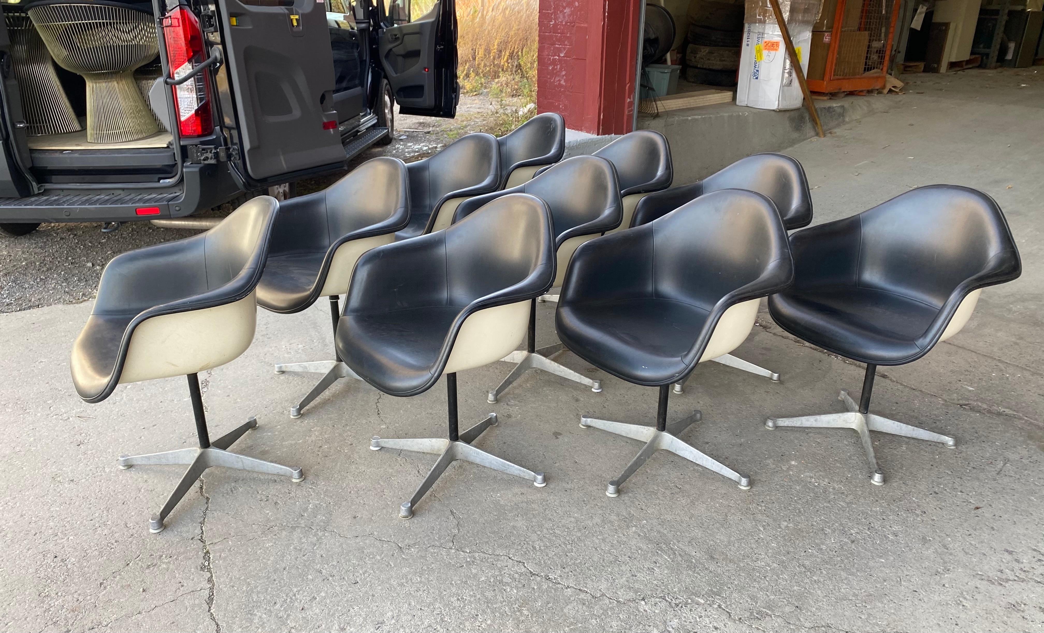 Set of 10 Charles and Ray Eames padded arm shell swivel chairs, Herman Miller/ alum star base, featuring white fiberglass shells, black padded upholstery, aluminum 4-star bases, nice original condition, minor blemishes to black Naugahyde, Classic