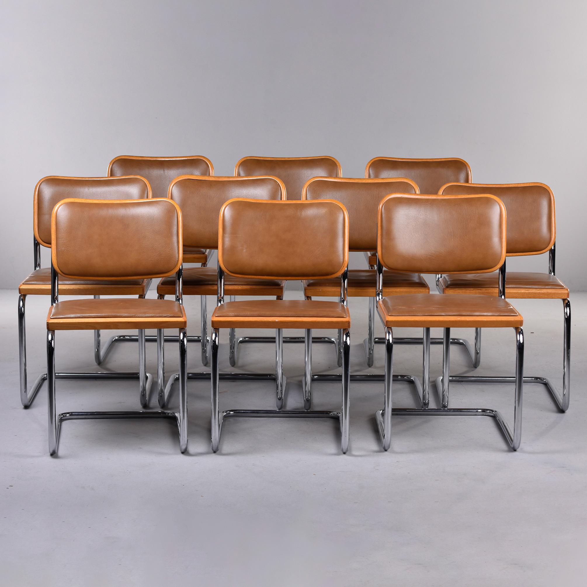 Circa 1974 set of 10 Knoll Breuer chairs. Chairs are marked and labeled with classic chrome cantilever frames, beech seats and backs with brown leather upholstery. Leather is in good condition, but underlying seat cushion foam has hardened and needs