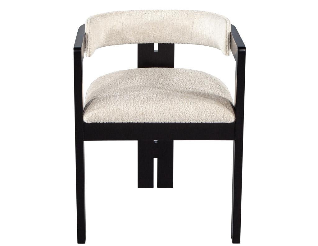 Introducing the Zeno chair by Carrocel, a modern curved dining chair made in Canada. Its unique shape is perfect for any home, from modern to contemporary. The chair is upholstered in a textured off-white cream fabric, with a satin black finished