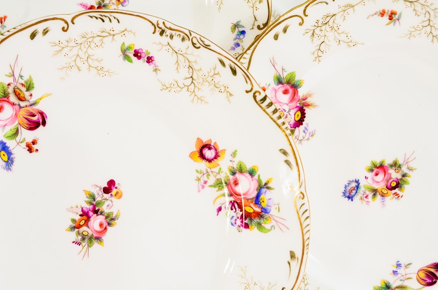 This set of 12 Cauldon 19th c English hand painted dessert plates feature detailed depictions of floral bouquets in bright primary colors that will blend beautifully with many styles and colorways. Add these to cobalt blue, cranberry, green or pink