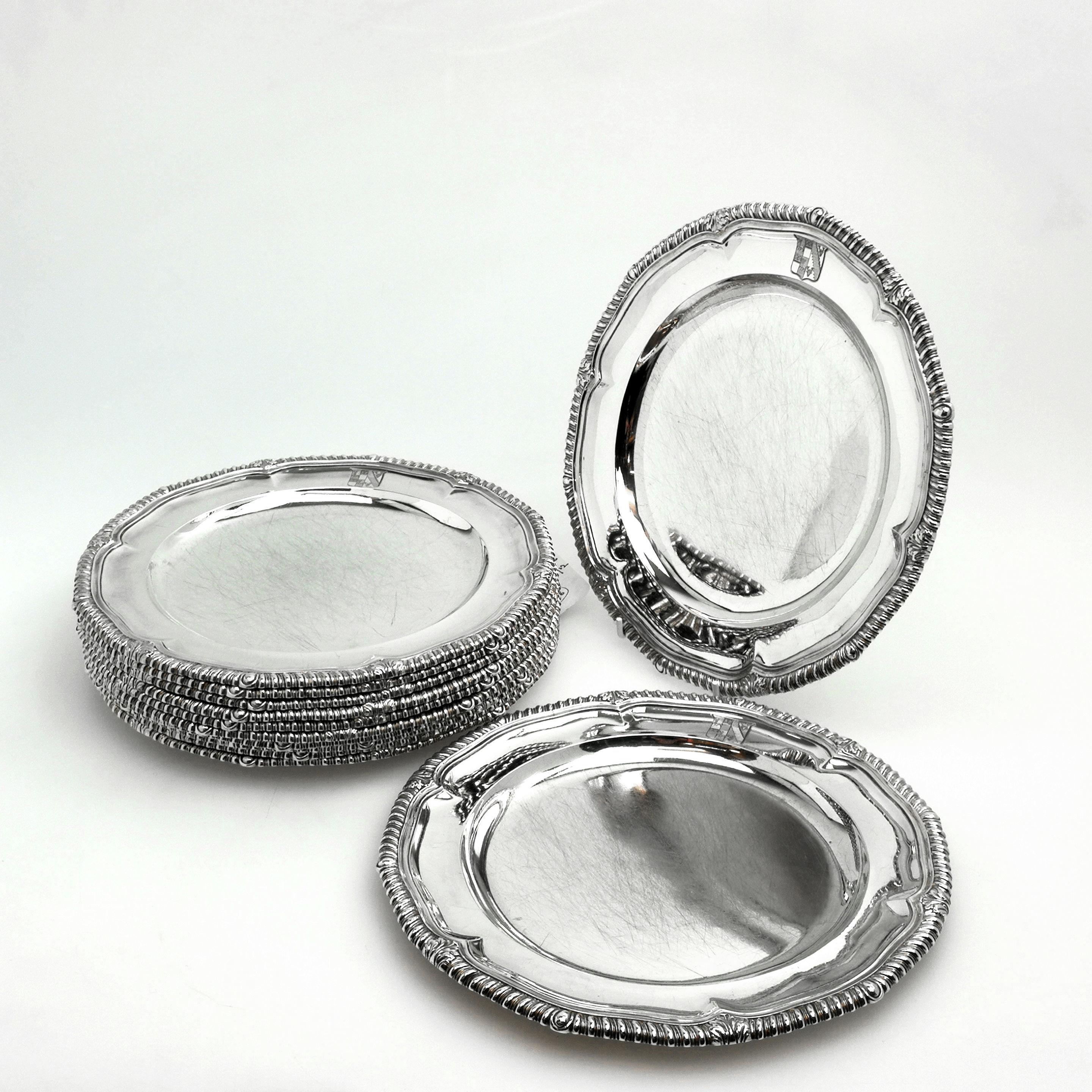 An impressive set of 12 Classic antique George III solid silver dinner plates with a traditional shaped Gadroon Pattern border. The plates each have a small engraved crest on the rim.
 
 Made in London in 1820 by Richard Sibley.
 
 Approx. Total