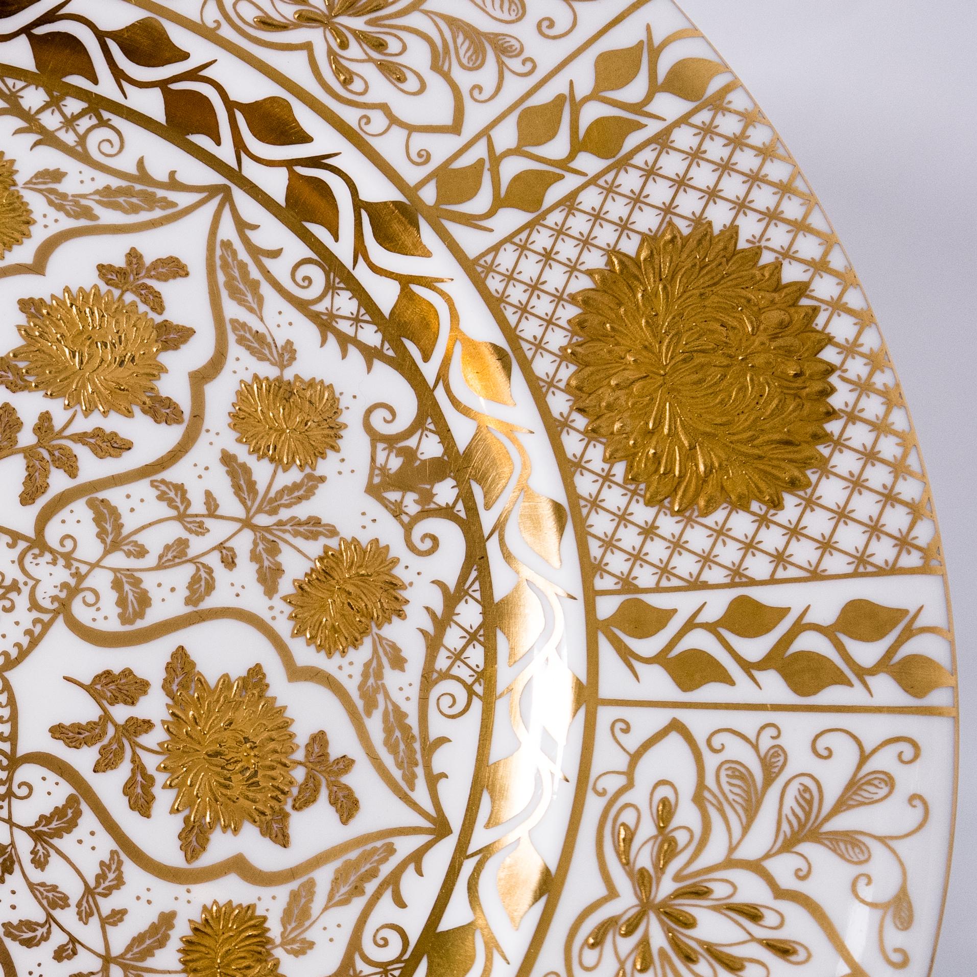 An elaborate set of custom chargers or presentation plates made for the re known London Retailer, Thomas Goode. Rich raised paste gilding in an elaborate florette design. Measuring a little over eleven and a half inches in dimension on a crisp white