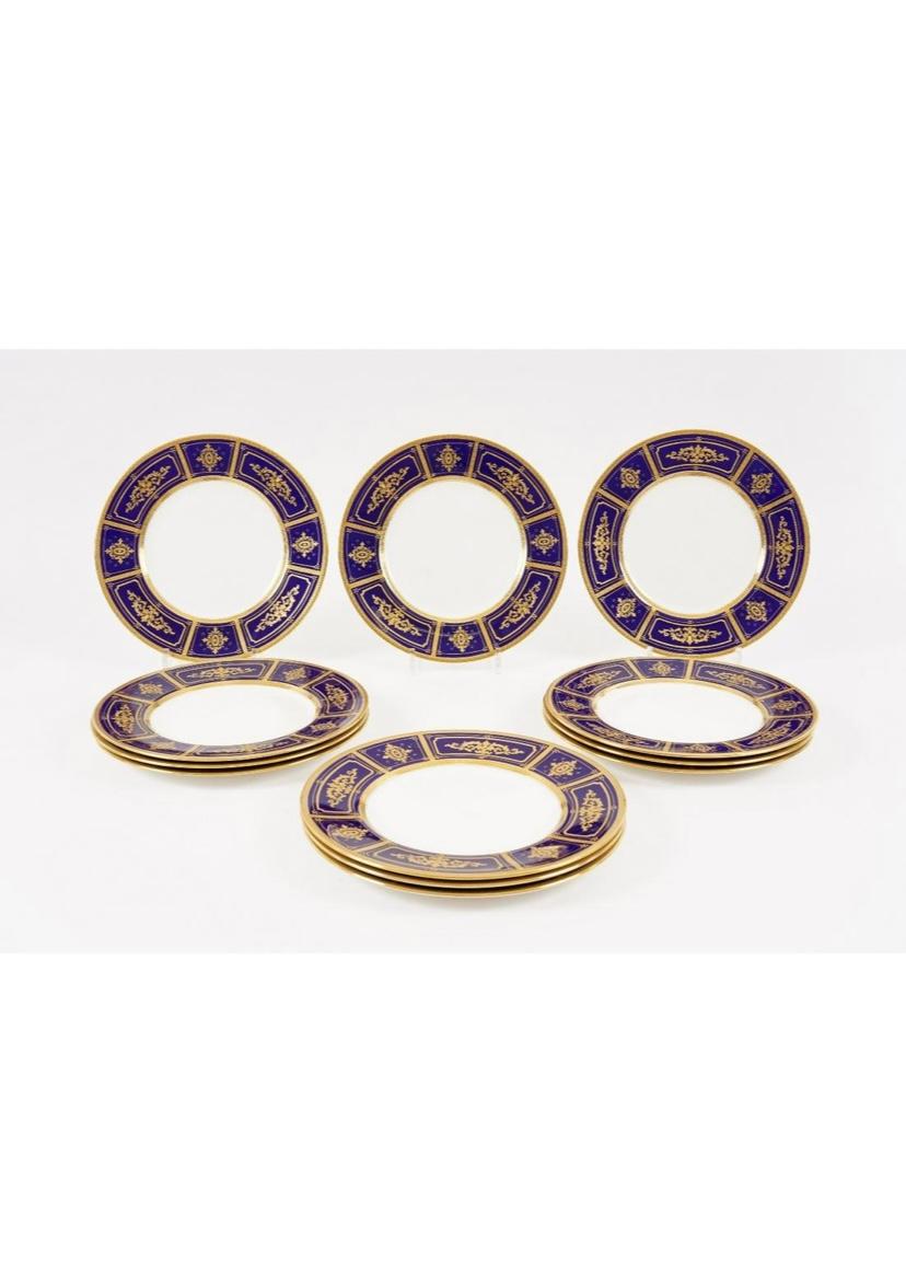 A stunning set of 12 cobalt blue dinner plates from Minton, one of our favorite and world re known porcelain factories. This set of 12 plates features precise raised tooled gilding in classical design on their collars. On crisp white porcelain,