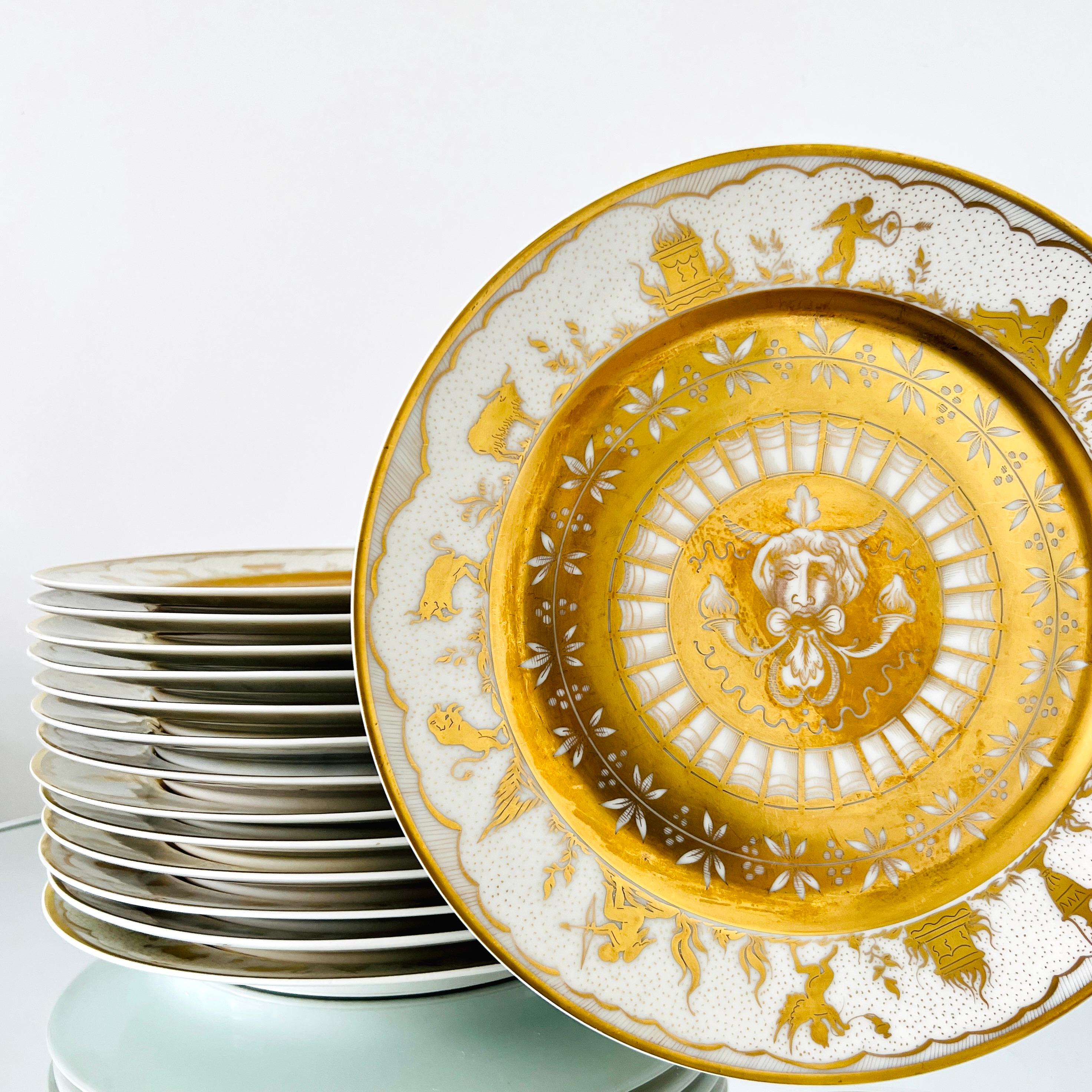Set of fourteen Le Tallec porcelain dinner plates with hand-painted designs in 24K Gold Leaf from the late 1950's. The exquisite set features Greek Mythology and Harvest themes and is decorated with motifs of satyrs, cherubs, sheep, lions, ancients