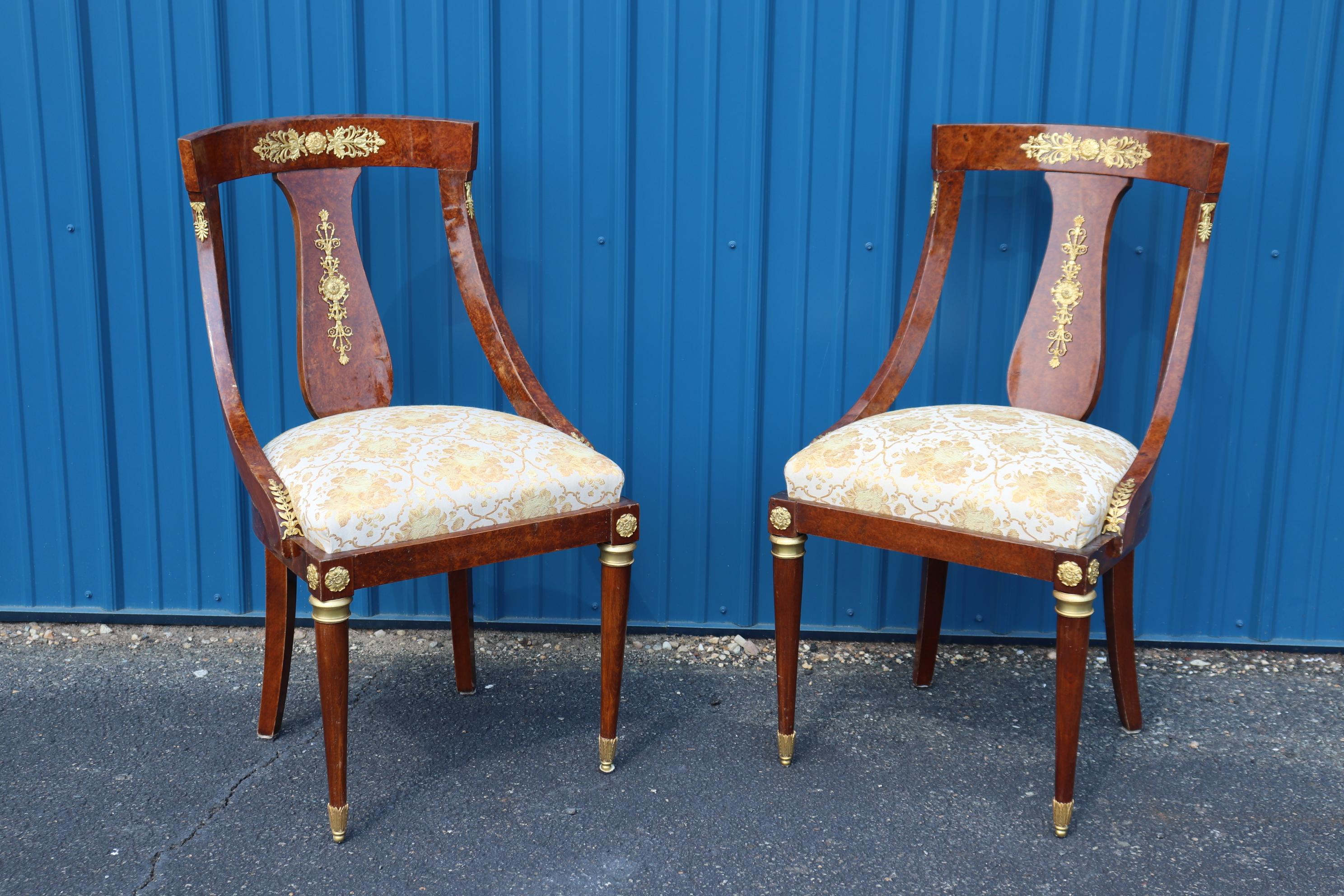This is splendid set of 16 French Empire style gilt dor'e bronze mounted dining chairs that match a 14 foot burled walnut dining table we have listed separately. The chairs are made of some of the best amboyna burled walnut we've ever seen and the