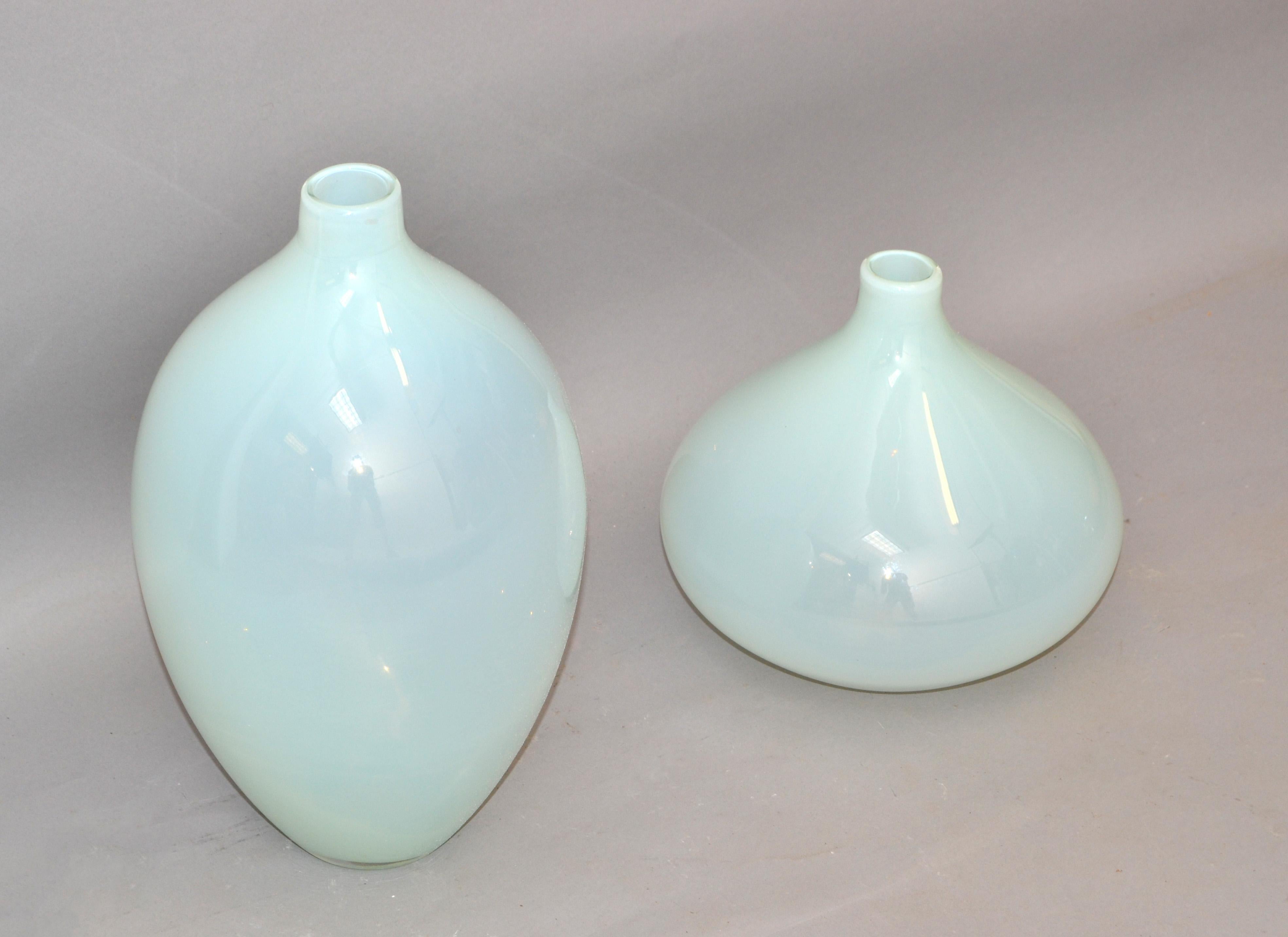Set of 2 translucent baby blue Mid-Century Modern handmade art glass vessel, vase, decanter in the Style of Blenko.
Round Vessels blown in clear and light blue Glass.
The Smaller Vase measures: 
Height: 8.5 inches.
Diameter: 9 inches.
Great for