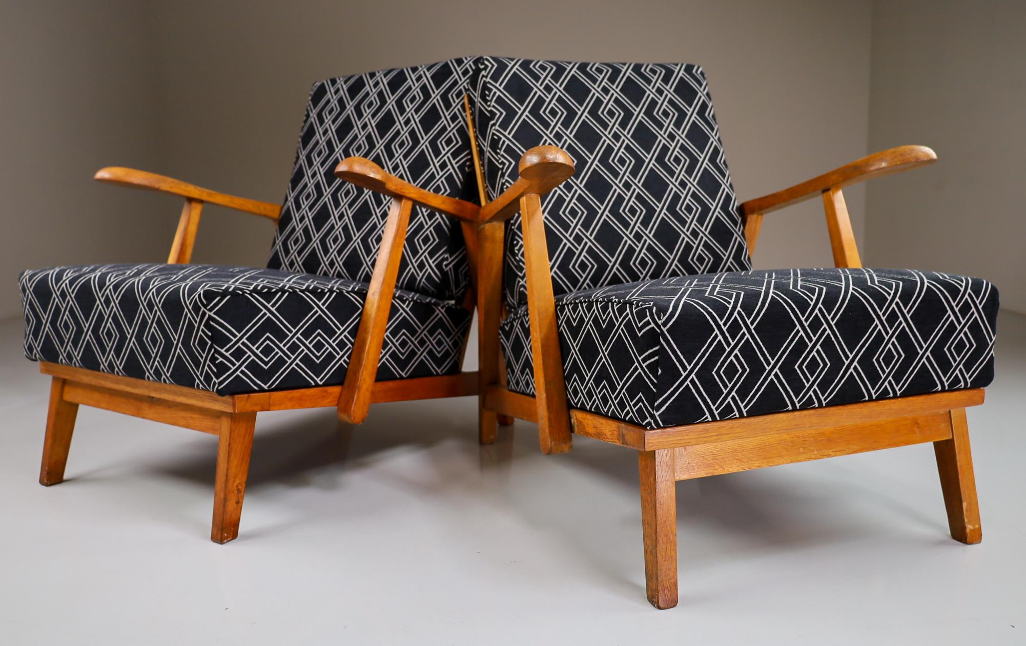 Pair of two original midcentury sculptural armchairs or lounge chairs manufactured and designed in France 1950s. Made of solid oak and professionally reupholstered. These armchairs would make an eye-catching addition to any interior such as living