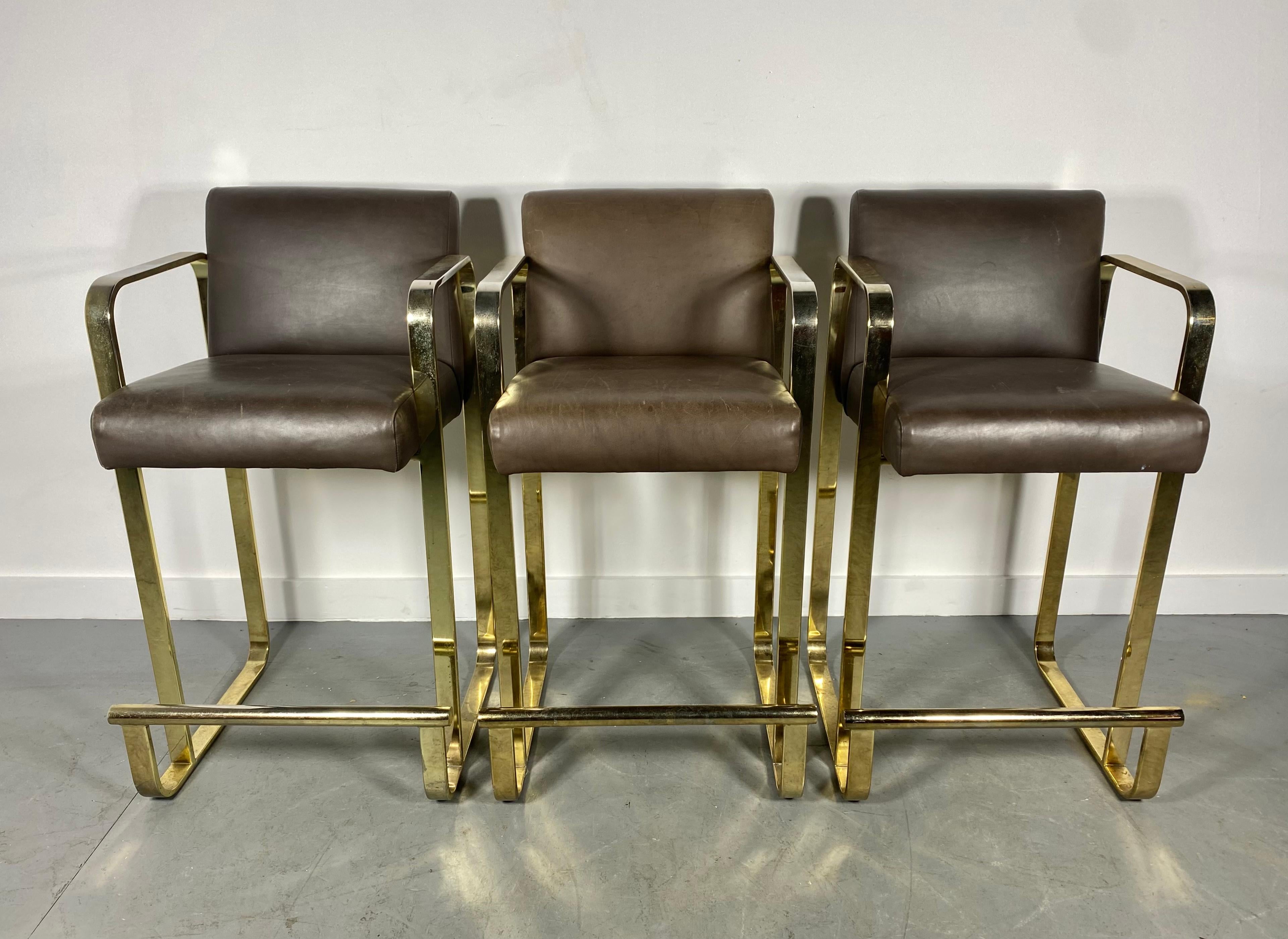 Elegant set of 3 brass (plated) and leather bar / counter stools attributed to Shelby Williams. in the style of Pierre Cardin. Super quality and construction. Nice original condition. Extremely comfortable. Arm height 33
