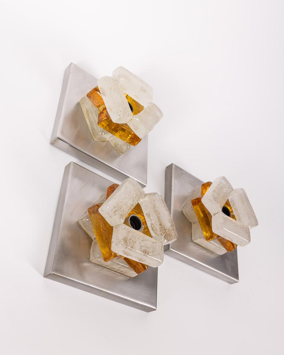 Set of three wall lamps with chromatro metal base and blown Murano glass frame, design Albano Poli for Poliarte, 1960s.

CONDITION:
In good, working condition, may show signs of wear given by time.

SIZING: 
Height 10 cm; width 19 cm;  Length 19 cm;