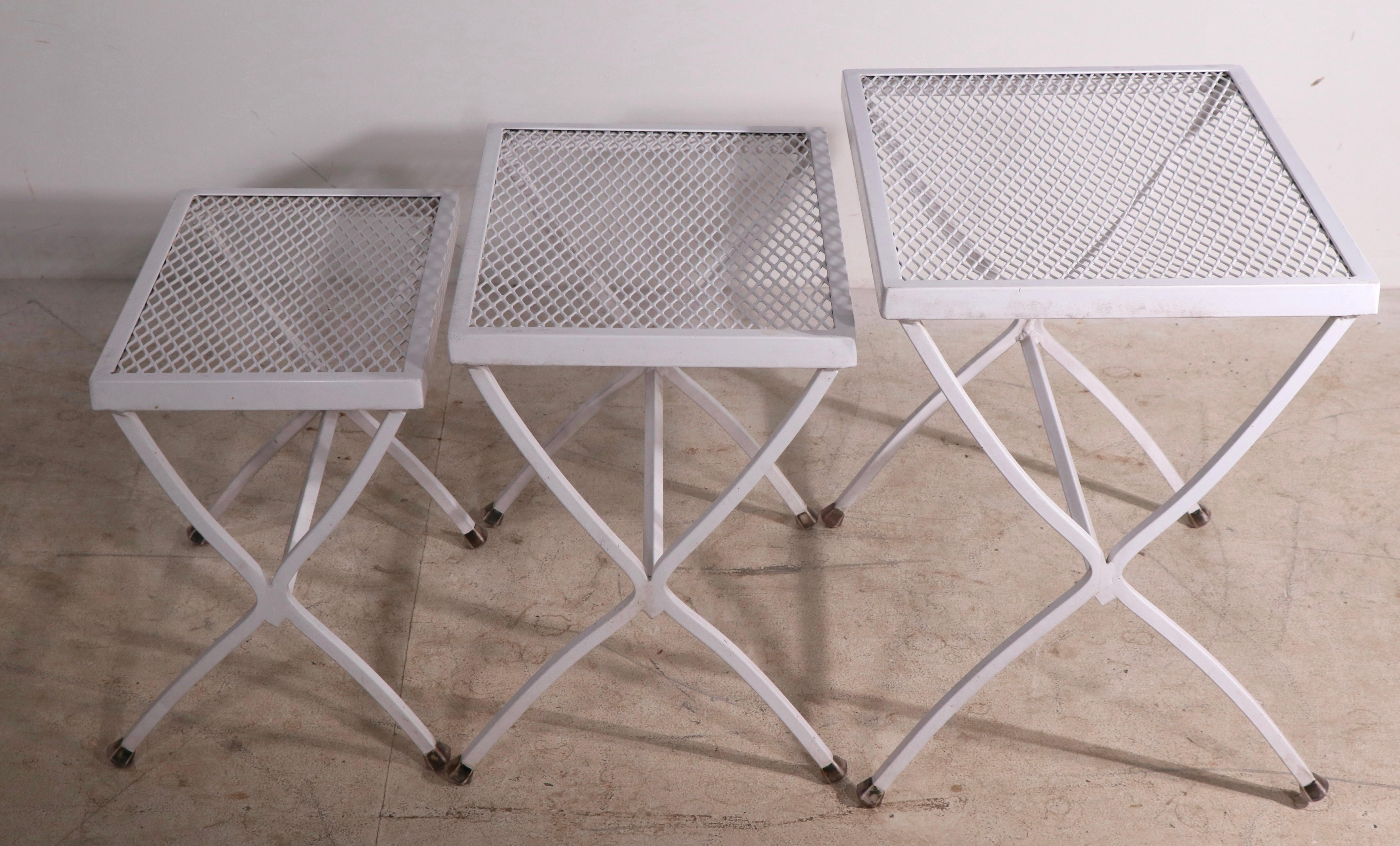 Chic architectural set of three nesting tables of wrought iron and metal mesh. The three tables are graduated in size, all are in very good, clean, original and ready to use condition. Usable as is, we also offer custom powder coating if you prefer