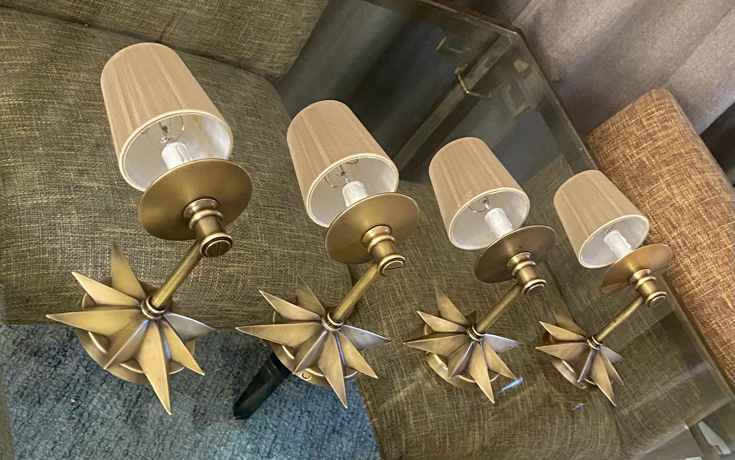 Set of 4 (four) 1930s deco period solid bronze 1 arm wall sconces light with sunburst or starburst motif. The unique star design wall lights are expertly crafted of thick solid bronze. Each sconce uses candelabra base bulb. Newly wired for us