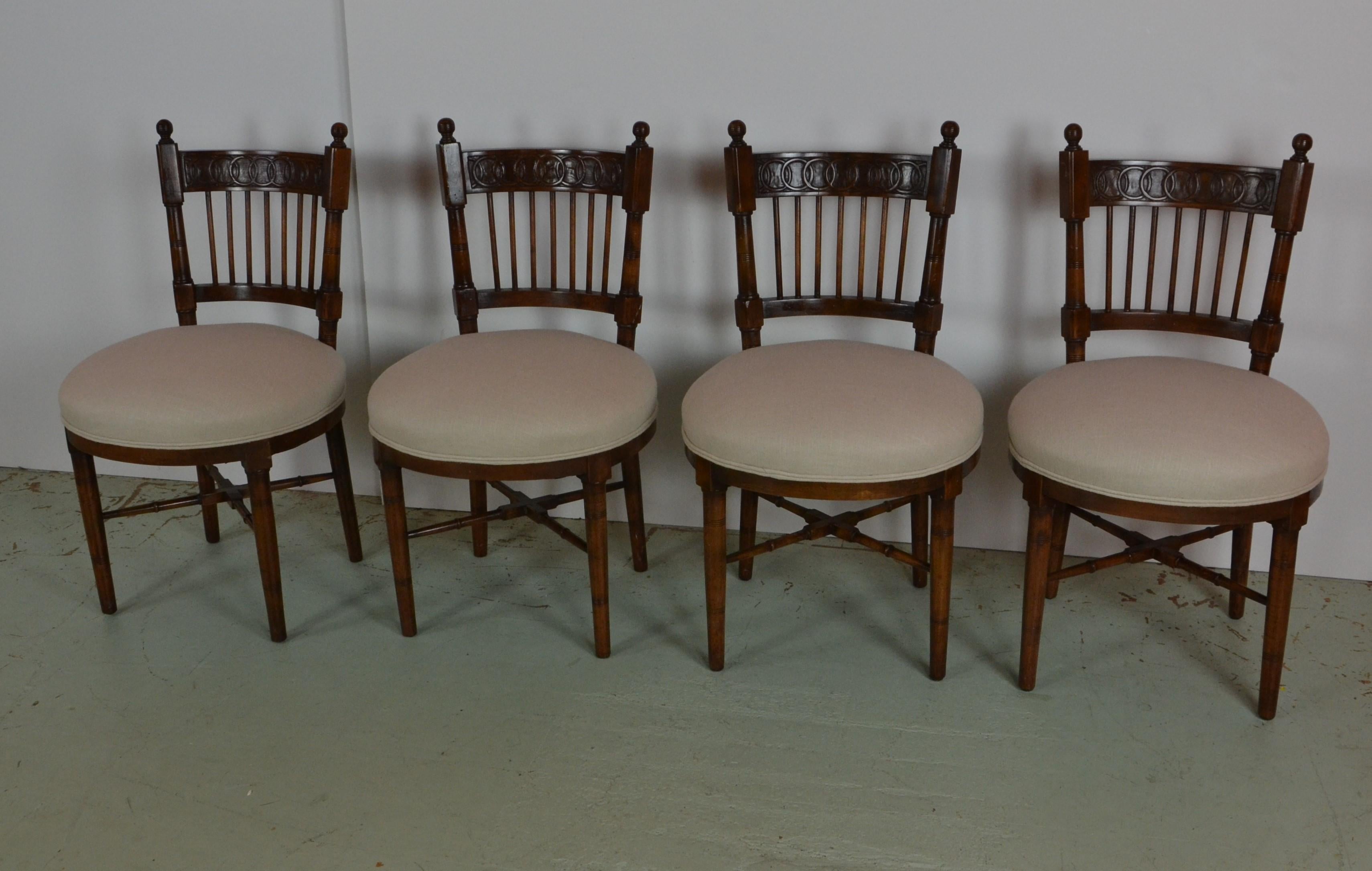 A set of 4 dining chairs with unusual styling. Possibly French Country. Back-splats decorated with a hand carved overlapping hoop design. Faux bamboo style stretchers. Mahogany stained beechwood. Newly upholstered in linen.
