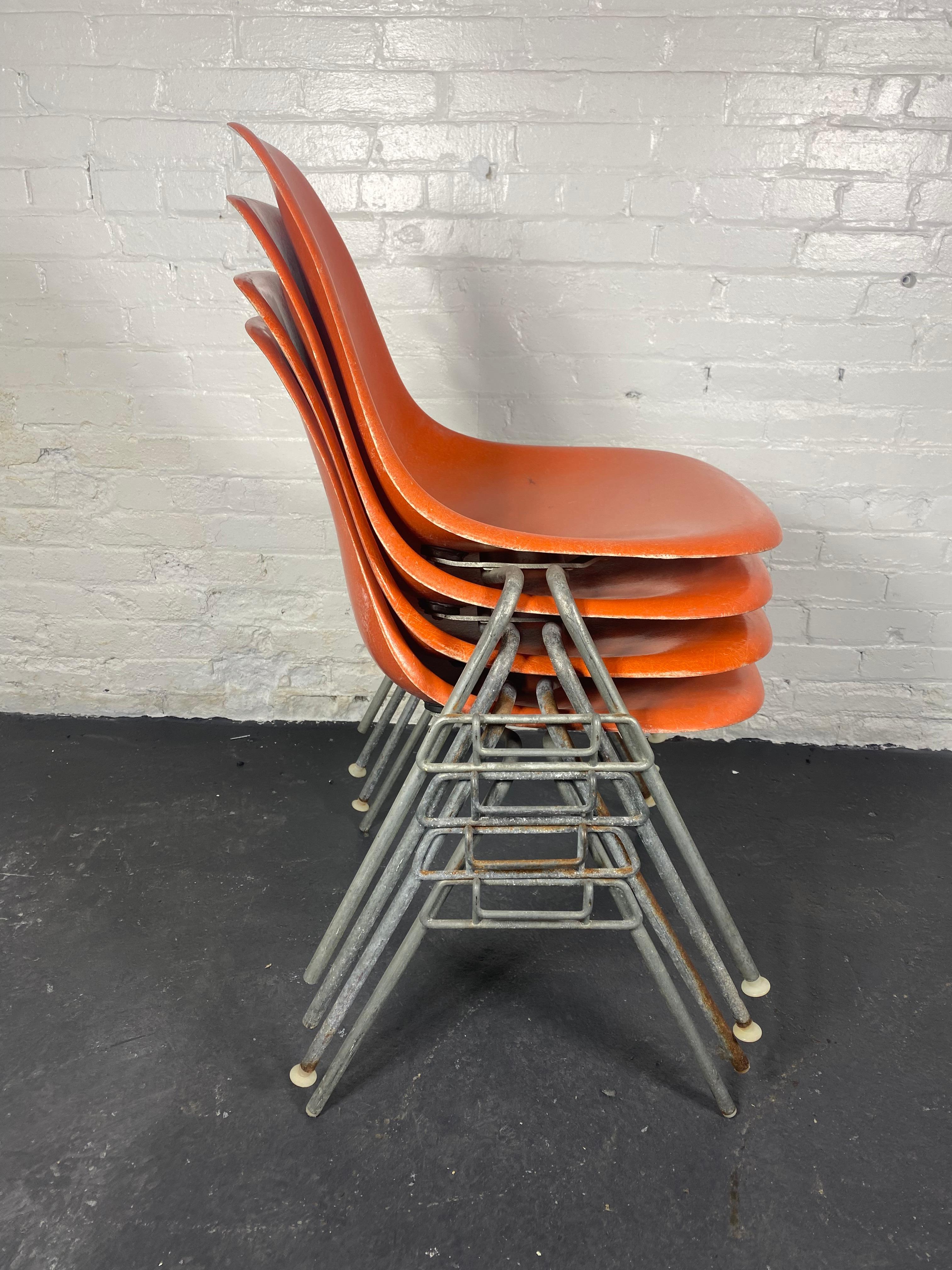 Great Set of 4 stackable dining room chairs by Charles & Ray Eames for Herman Miller, cLASSIC mID cENTURY Modern design.. , circa 1970 (late 1960s 
The chairs are marked on the underside with 'herman miller'.
A molded orange fiberglass glass shell