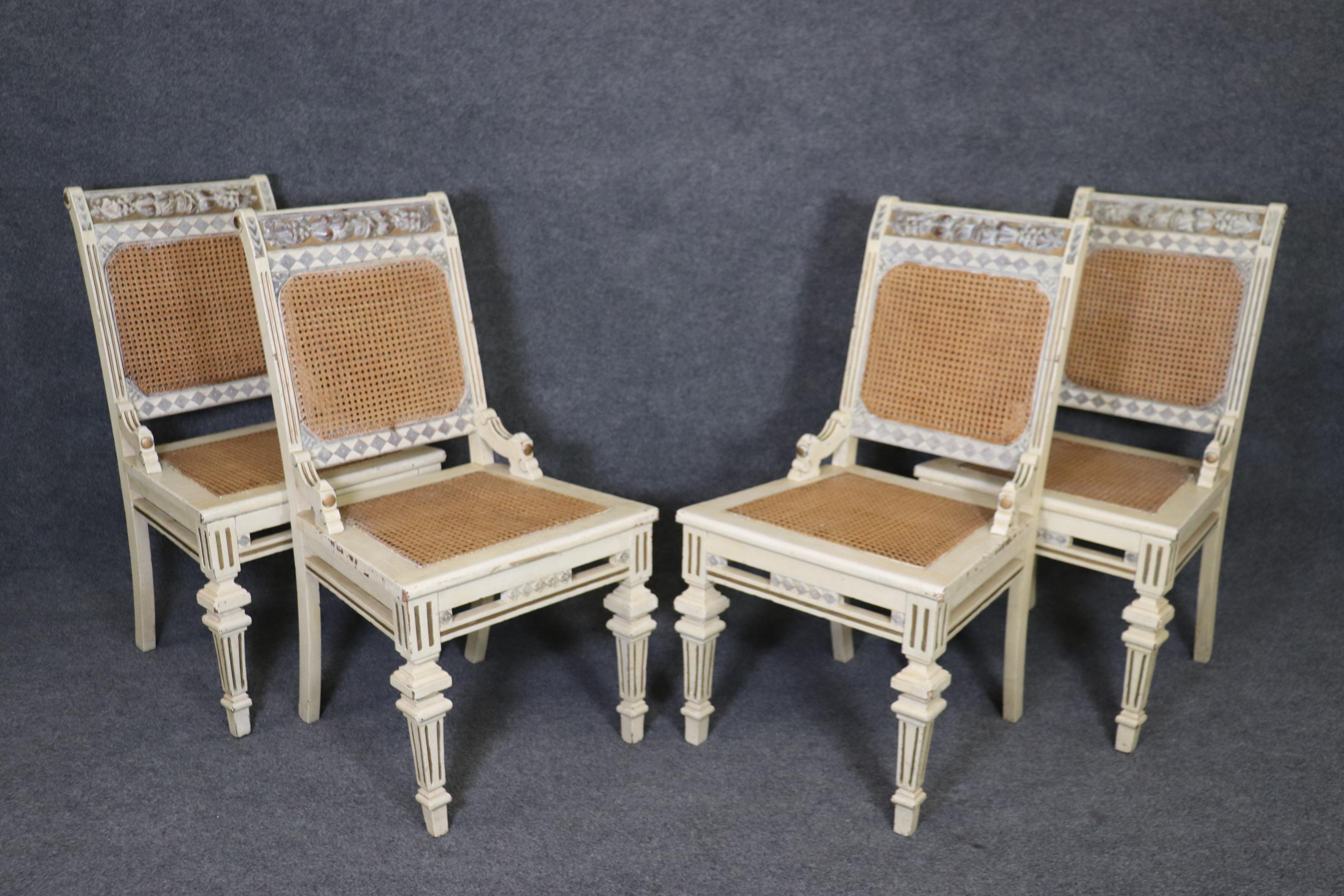 This is a beautiful set of distress painted antique white French country dining chairs with cane backs and seats. The chairs are in a distressed painted finish with minor signs of age and wear as to be expected. The chairs measure 37 tall x 20 wide
