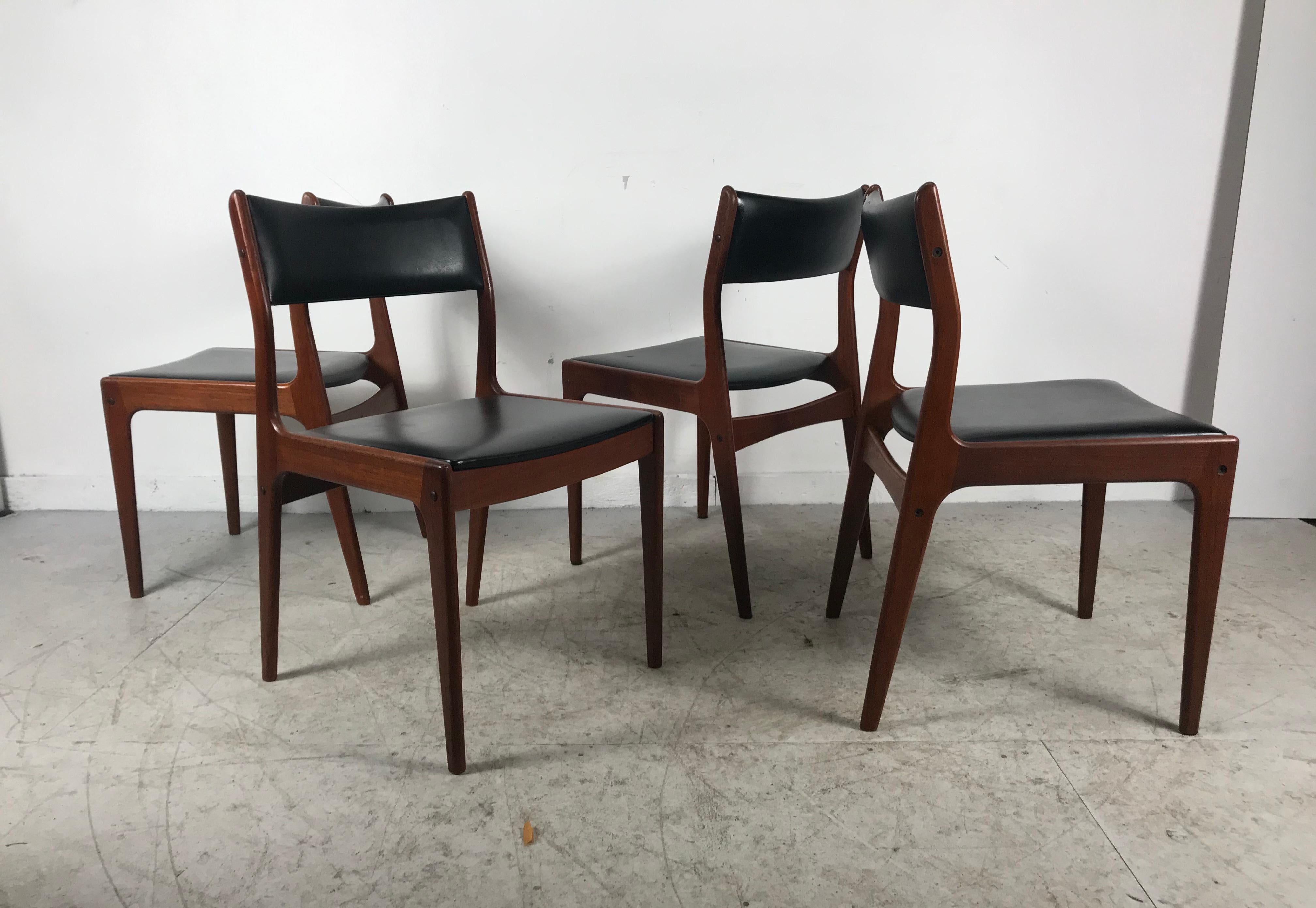 A set of four 1960s Danish modern rosewood dining chairs by designer Johannes Andersen, made in Denmark by Uldum Møbelfabrik: model UM85. A Classic of Danish design. Made of solid rosewood, features curved backrests set on angled brackets, padded