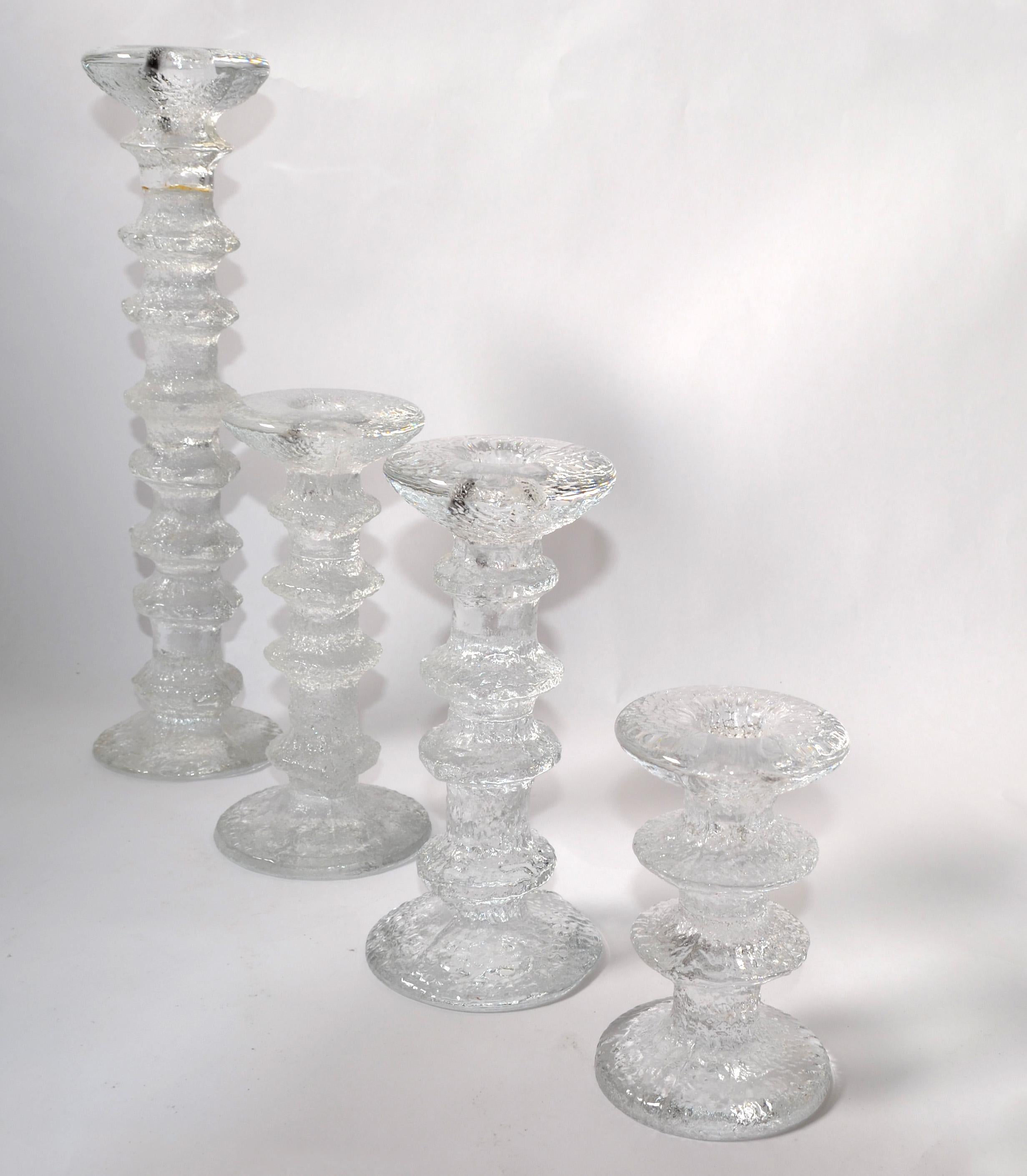 Set of 4 Scandinavian Modern Finland Iittala Art Glass with bubbles Festivo Candle Holders designed by Timo Sarpaneva, made in the late 1970s.
Top Candle hole measures: 0.75 inches.
Core Diameter measures: 2.75 inches.
Height graduates from: 12.25