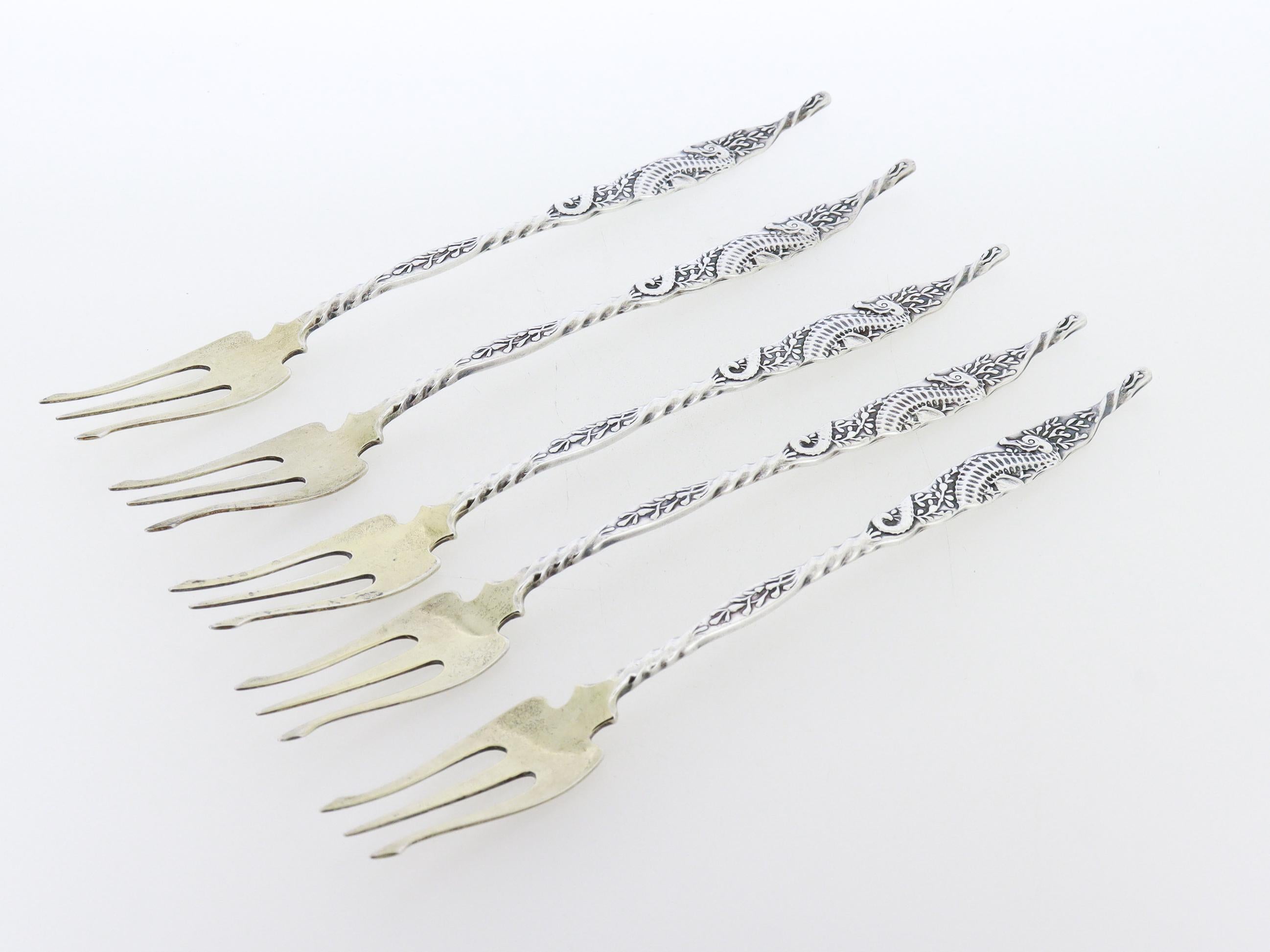 Un set di 5 raffinate forchette da mare antiche.

In argento sterling.

Da Whiting.

Il manico di ogni forchetta è decorato con un cavalluccio marino in rilievo e piante oceaniche.

Semplicemente un meraviglioso set di forchette da mare in argento