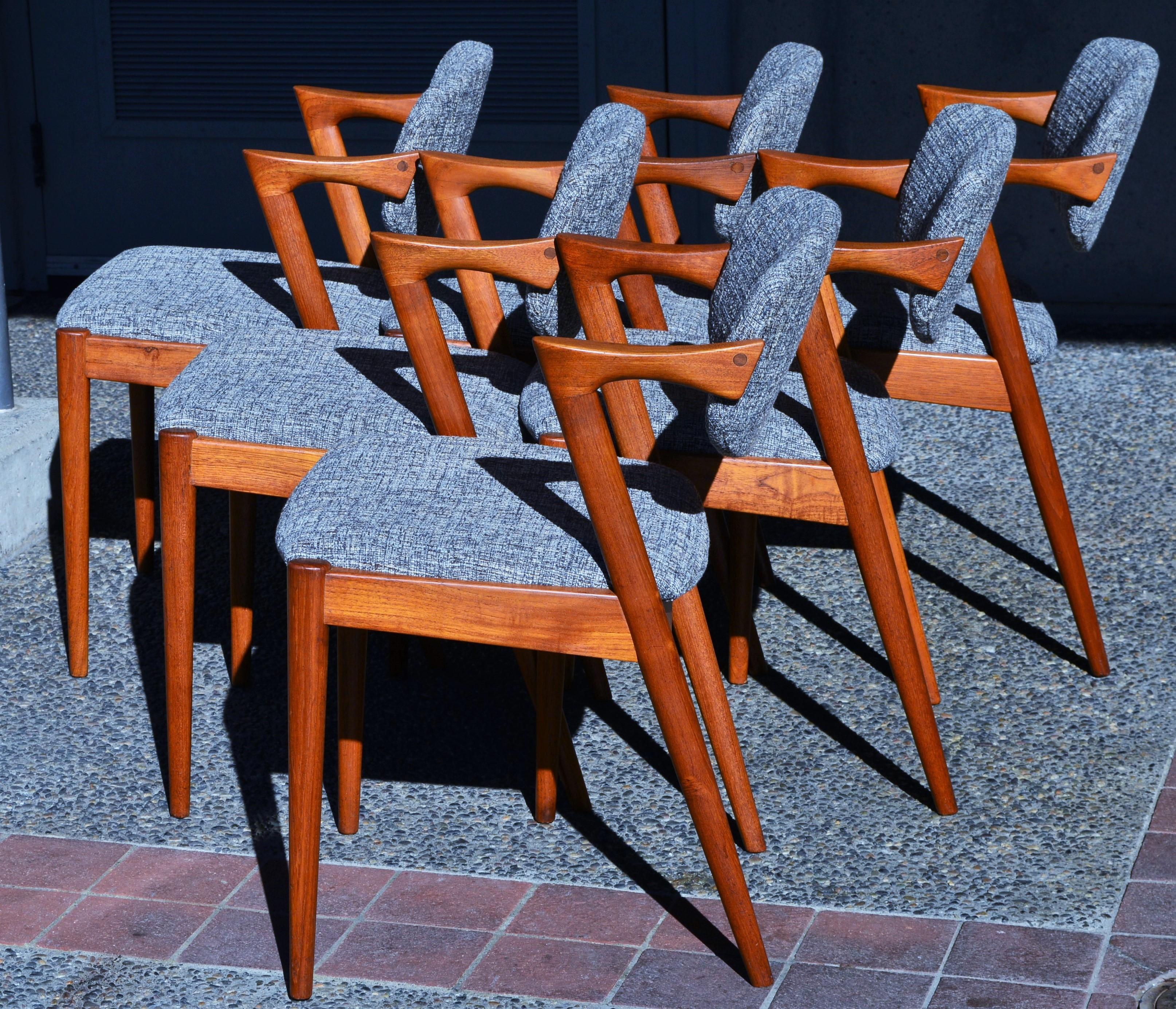 This incredible set of six Danish modern teak dining chairs were designed by Kai Kristiansen in the 1960s. Featuring gorgeous sculptural lines, such as the angled, truncated armrests, and the inwardly splayed back legs. The set has been reglued,