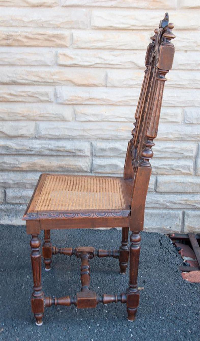Vintage ornately carved solid French oak dining chairs. A set of 6 from the Brittany region of France. The seat is handwoven cane. The carving is very Fine and is featured throughout the chairs. They are functional as well as beautiful. Seat H 18.5