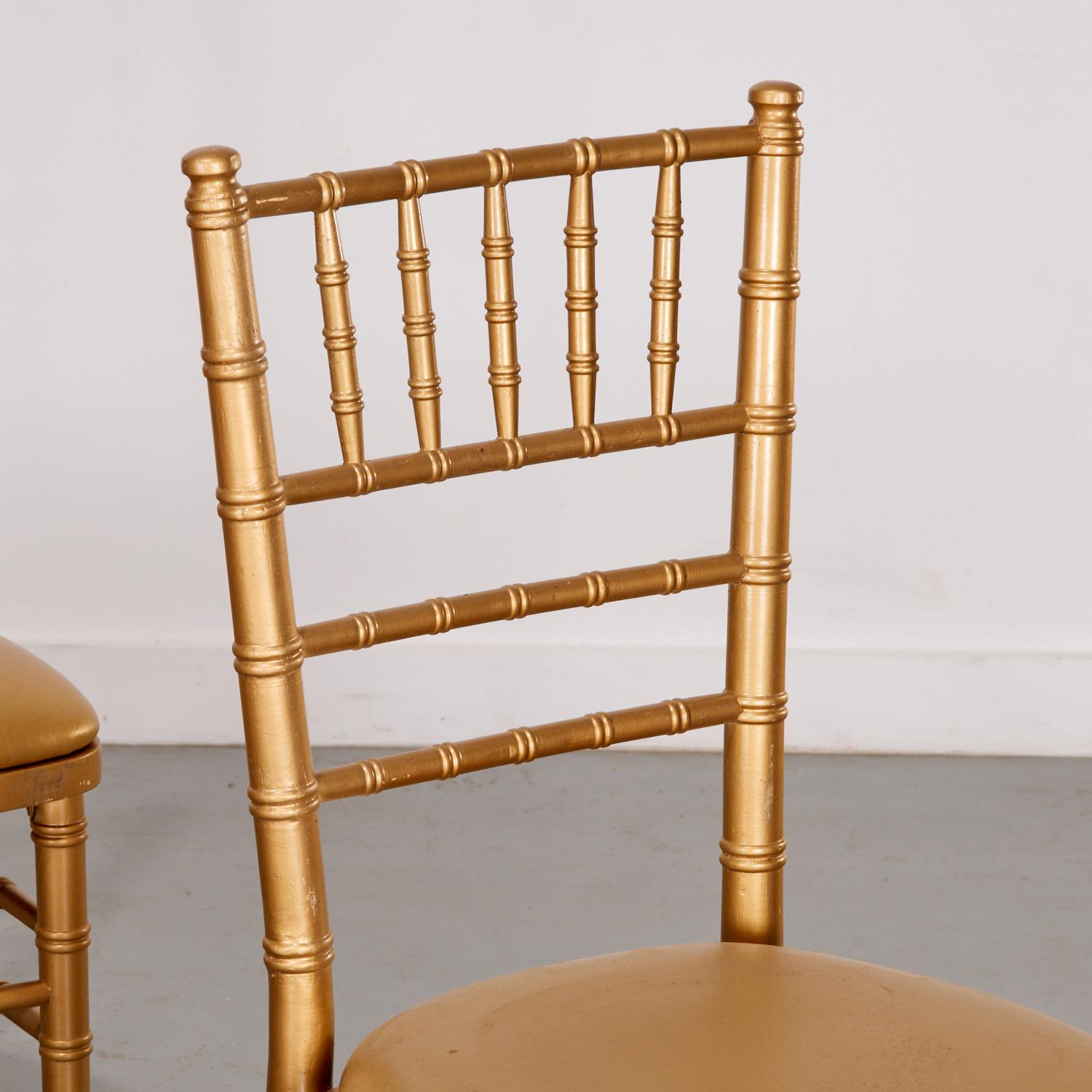 20th c., a set of six classic Chiavari-style chairs, known for their lightweight, elegant, and stackable design. The chairs are constructed from a sturdy material and have a metallic gold finish, giving them a glamorous and sophisticated look. The