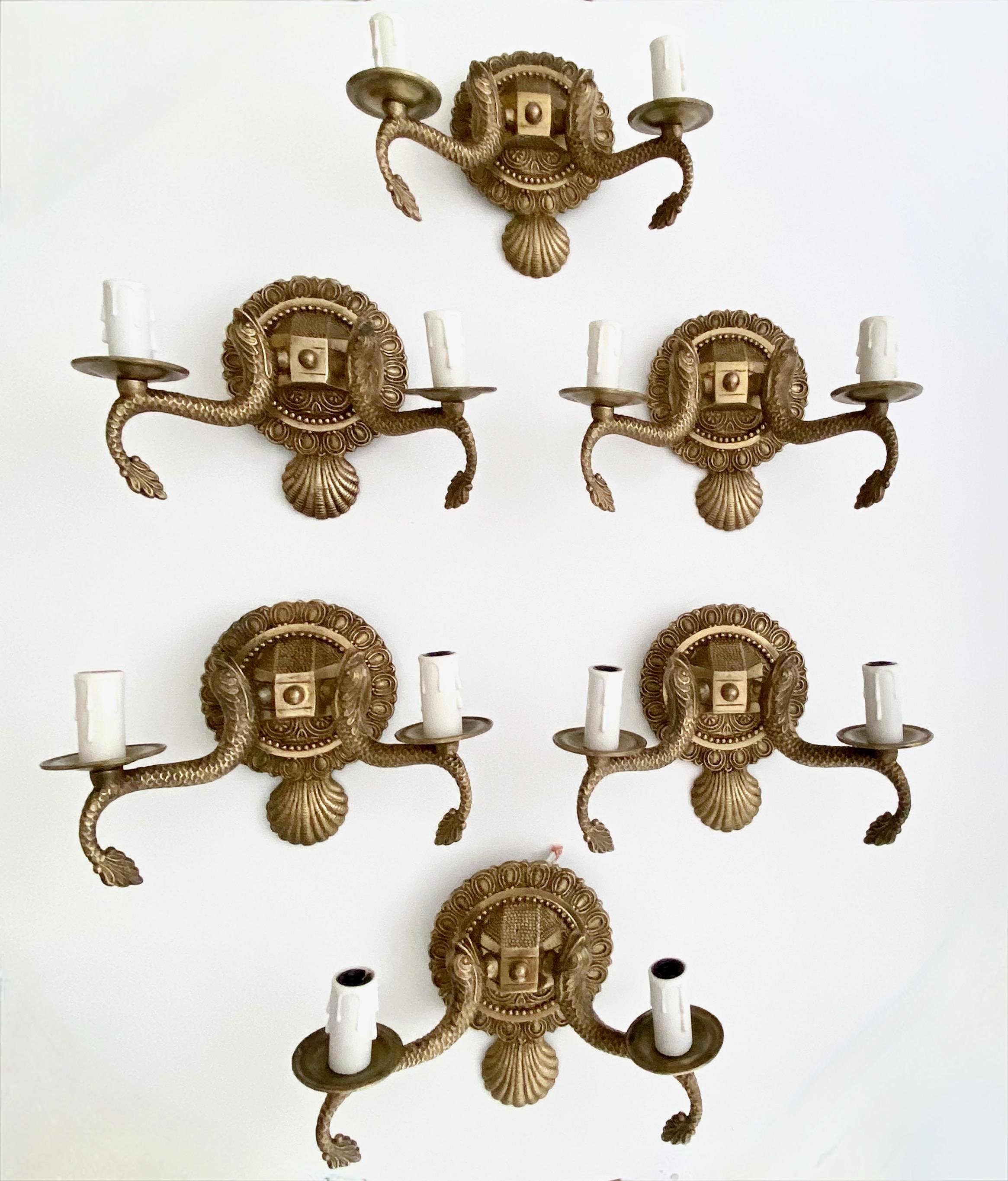 Set of six (6) of European two-light neoclassic style brass wall sconces with dolphin and claim shell motif. Expertly crafted with nice quality detailing throughout. Newly wired with new candelabra sockets. Additional pairs available under separate