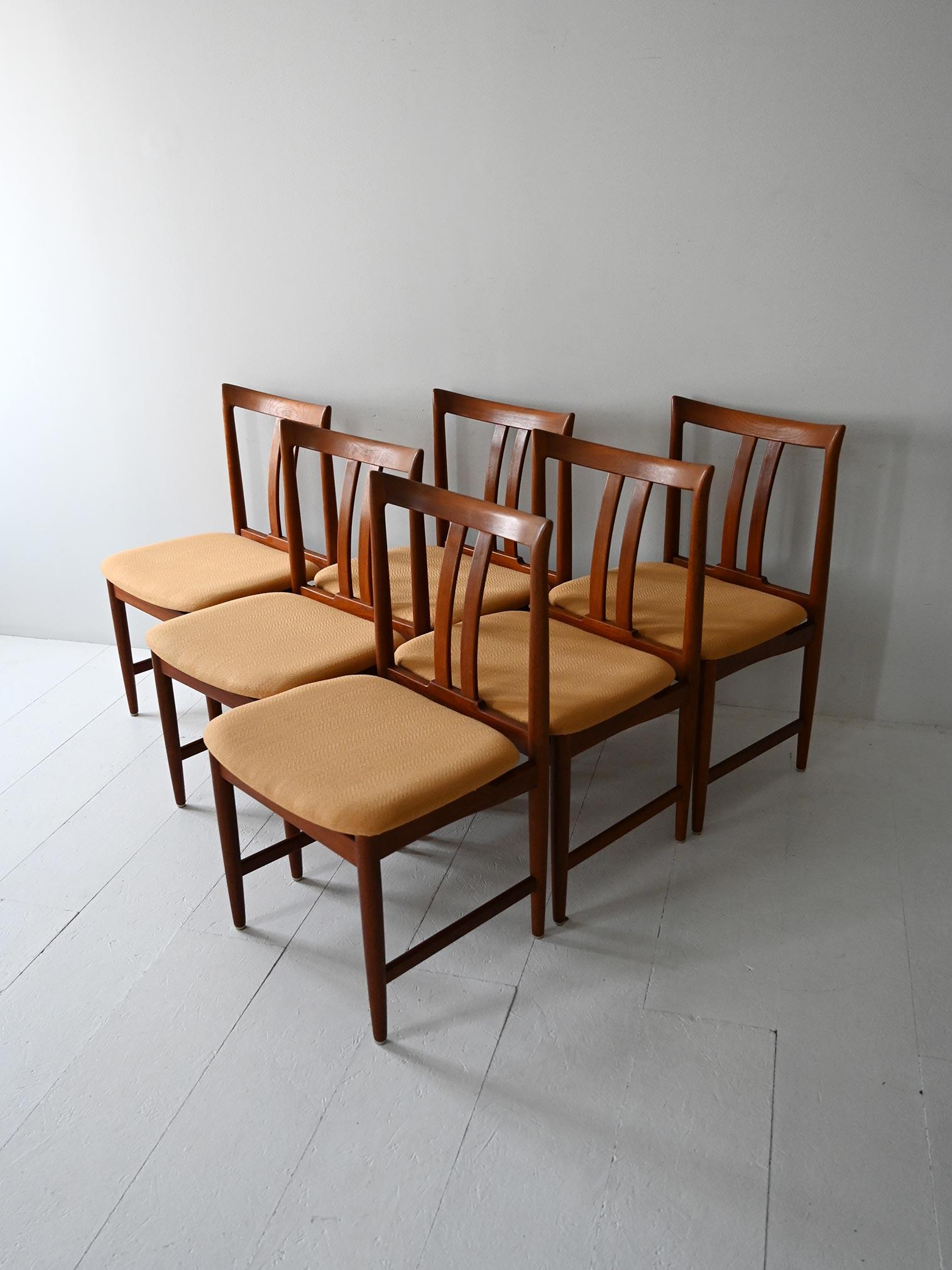 Set of six teak chairs with curved backs and original eggnog-colored upholstery. Elegant and well-proportioned design.

Set of six Scandinavian teak dining chairs from the 1950s. The frame has turned legs and neat details, with a back slightly