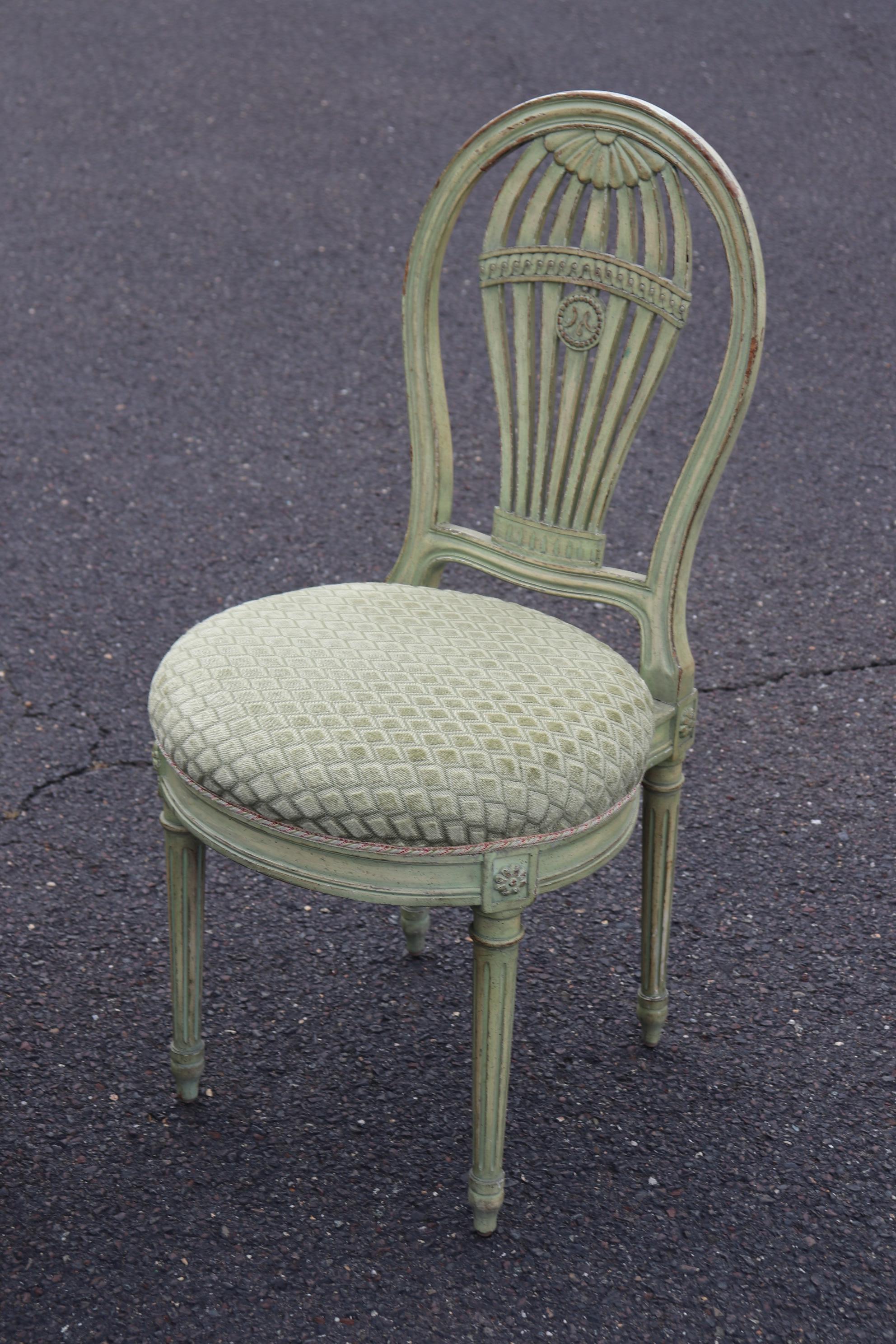 This is a fantastic set of 12 signed Maison Jansen balloon back Louis XVI dining chairs. They feature a soft green painted finish and matching velvet upholstery. They are in very good antique condition with minor wear and signs of age but don't
