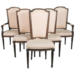 Ensemble de six chaises de salle à manger à dossier haut en noyer sculpté de style Louis XVI, vers les années 1940