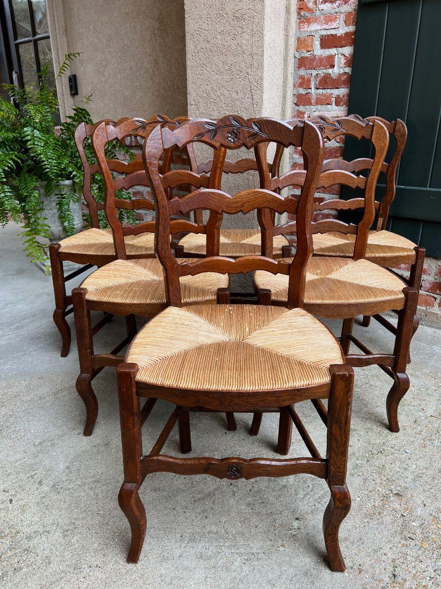 Set 6 vintage French carved oak ladder back dining kitchen chair rush seat.

Direct from France, a lovely set of 6 vintage French chairs with classic French style. Beveled, serpentine ladder backs with carved floral design to the upper crown.